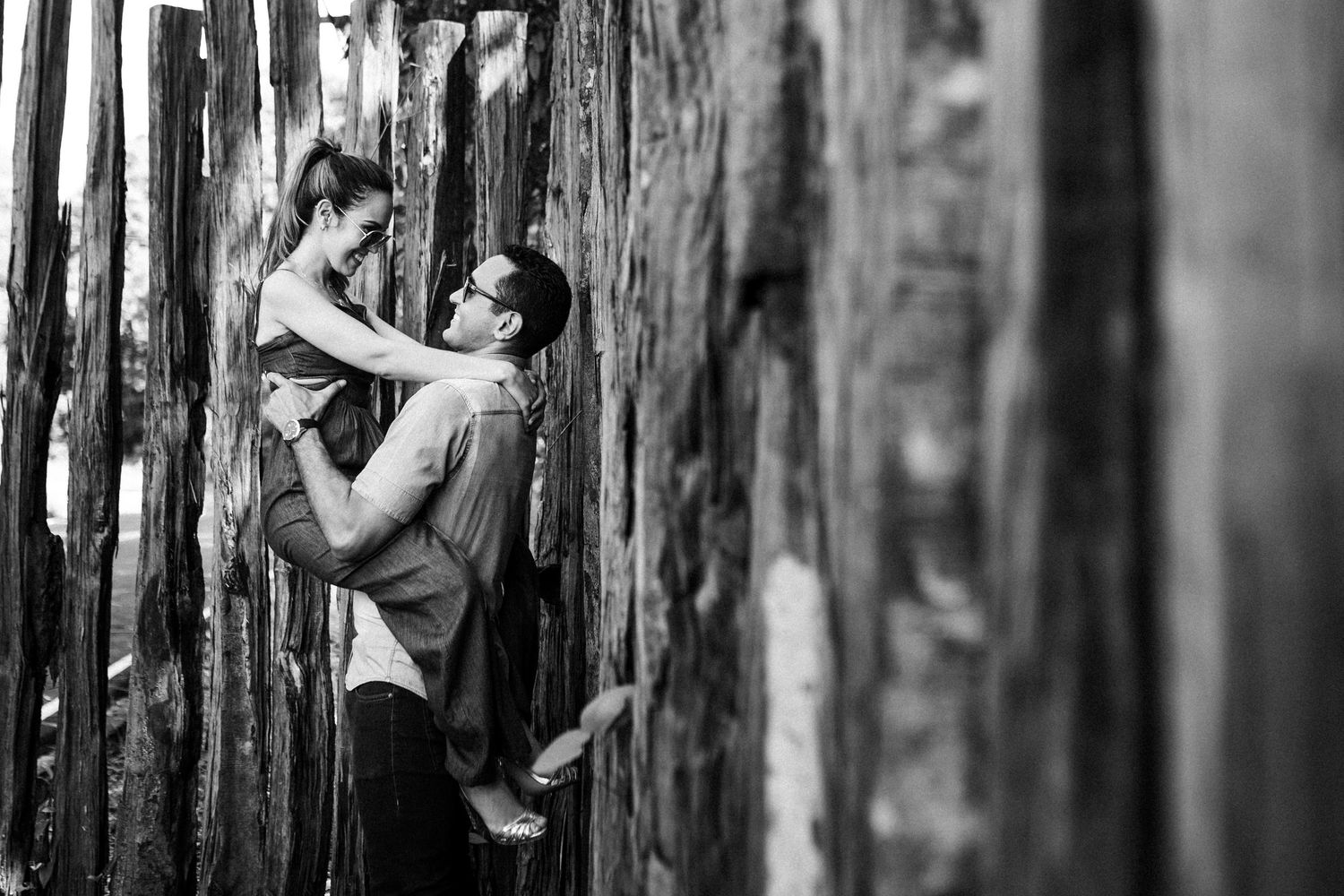 Black and white photo series showing a person leaning against rough wooden posts in dramatic lighting.