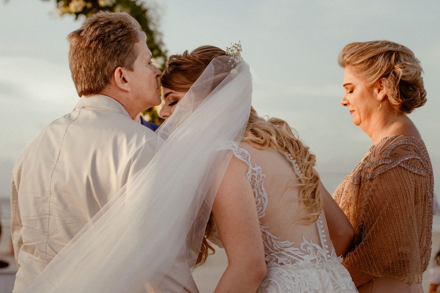 A romantic beach wedding photo series showing intimate moments between a couple during golden hour.