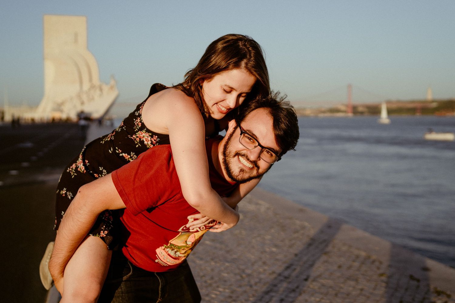A couple enjoys an affectionate moment together at sunset on a sandy beach.