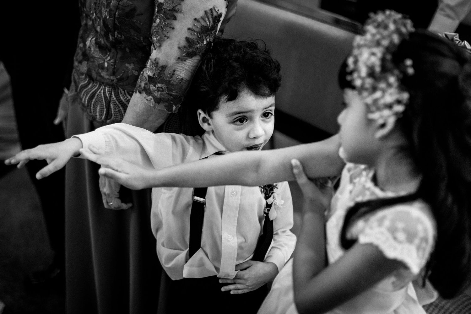 Black and white photo of young children playing during a wedding celebration.