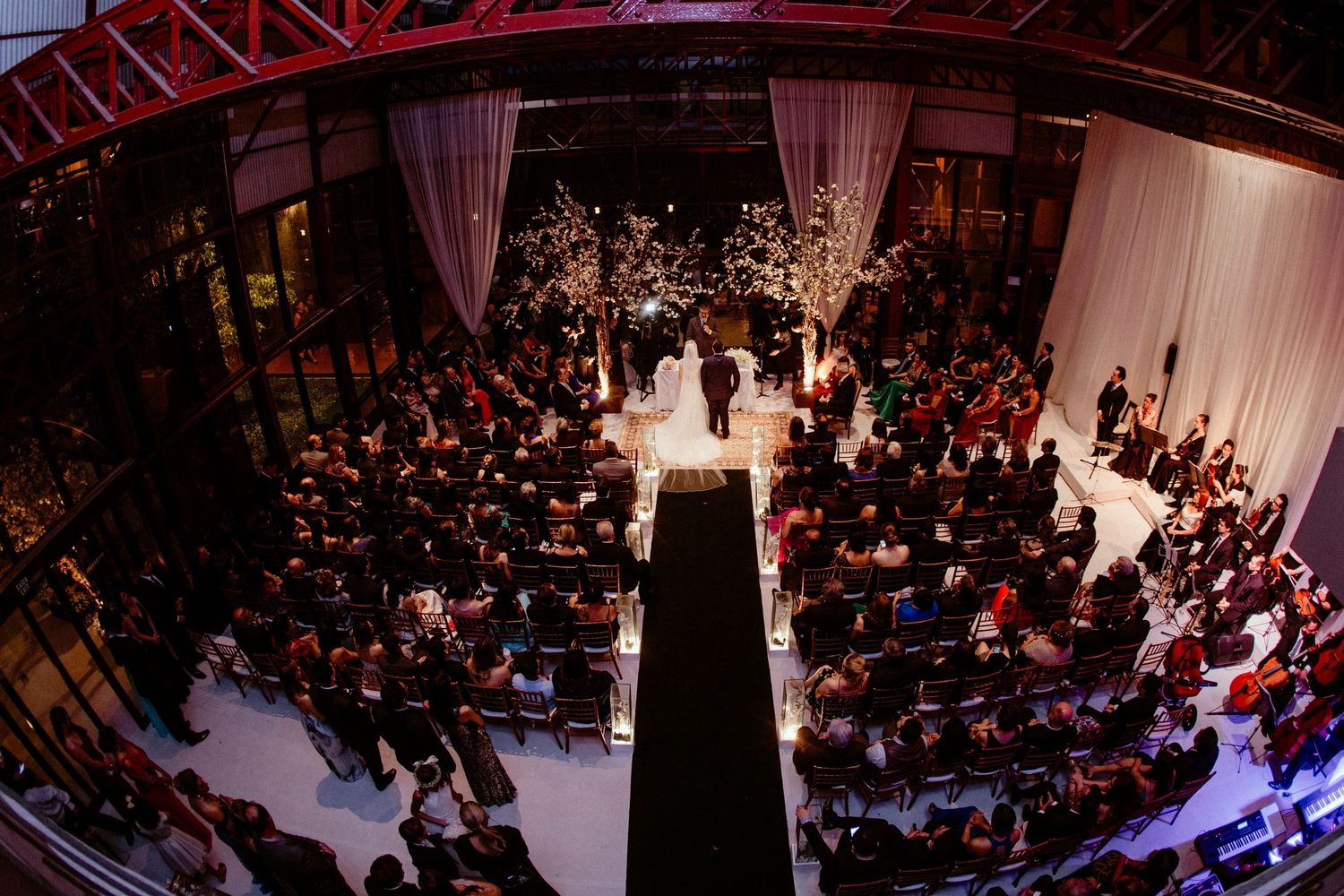 An overhead view of an elegant indoor wedding ceremony with illuminated floral decorations.