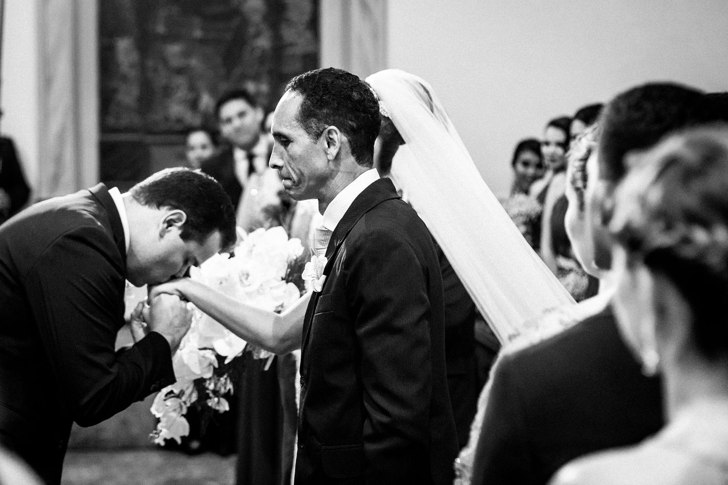 Black and white photo capturing an intimate moment during a traditional church wedding ceremony.