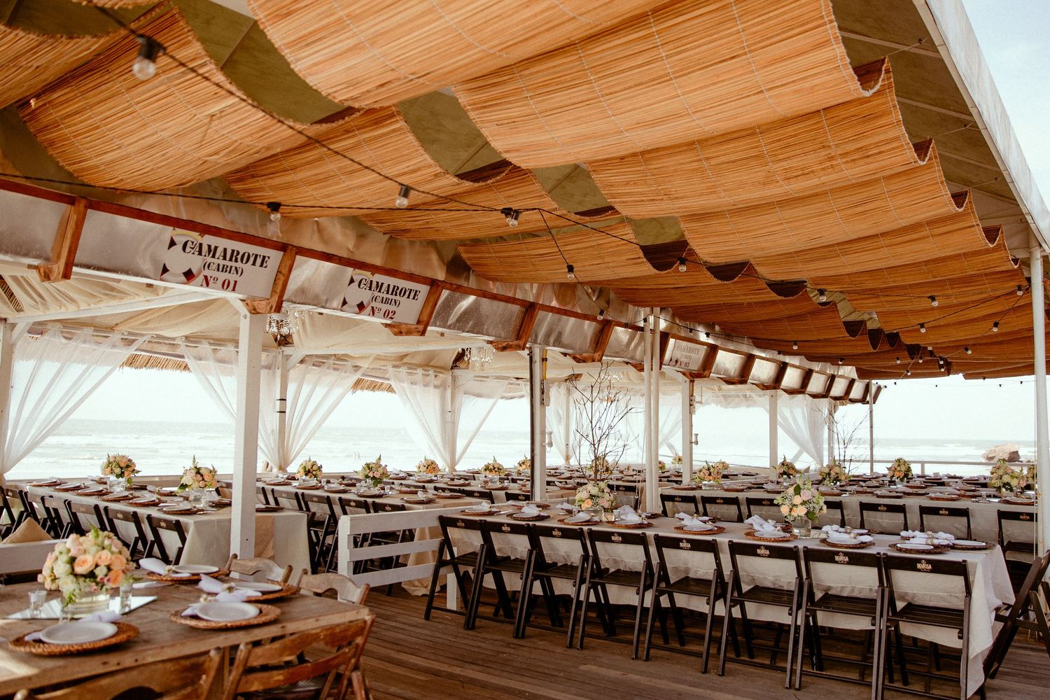 Upscale banquet hall with wood beam ceiling, nautical decor and elegant table settings for formal dining experience.