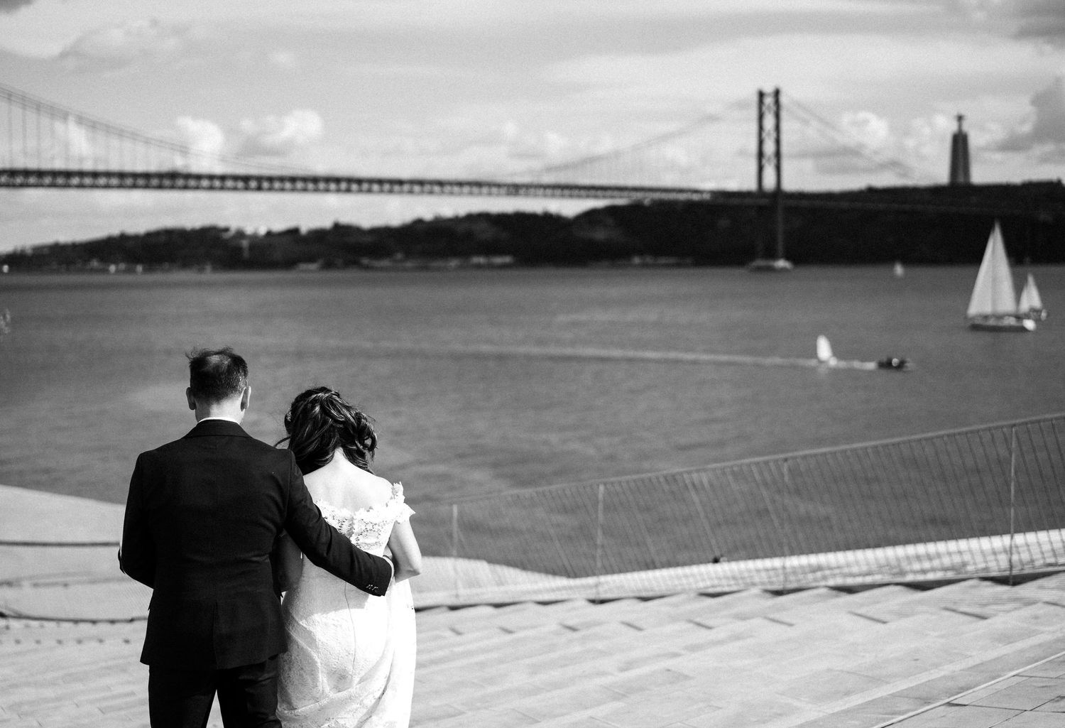 Black and white panoramic image sequence set next to a waterfront bridge and harbor with silhouetted figures.