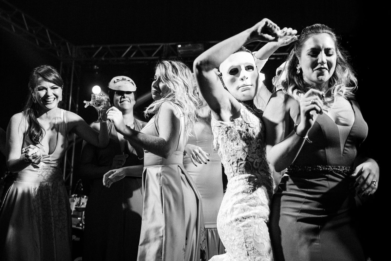 A series of black and white photos showing people dancing and celebrating at what appears to be a wedding reception.