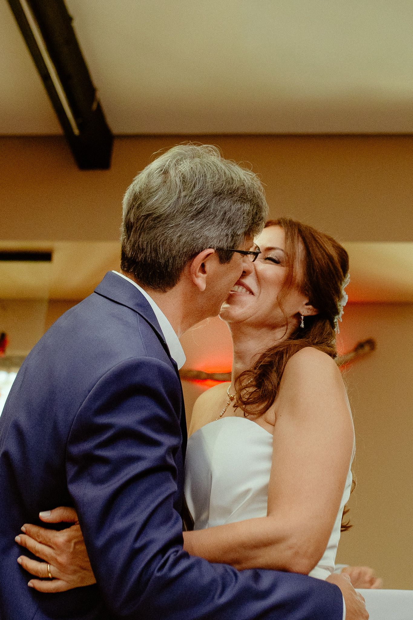 A romantic sequence of wedding kiss photos showing a couple in a navy suit and white dress embracing.