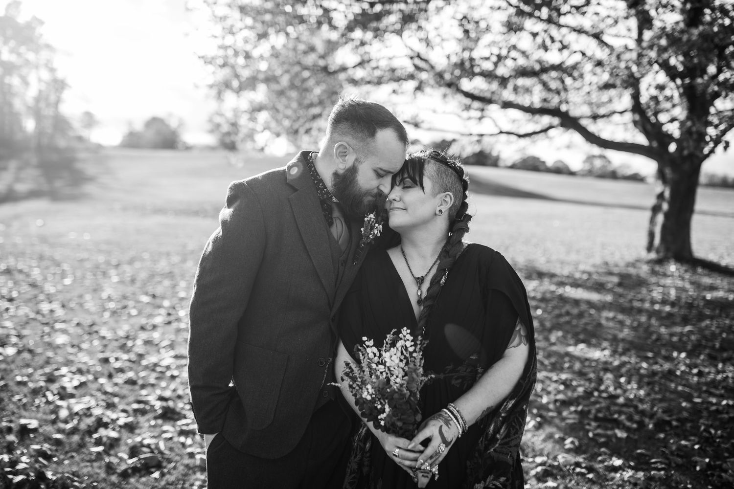 The bride is wearing a black floral dress, and the groom has a brown suit on.