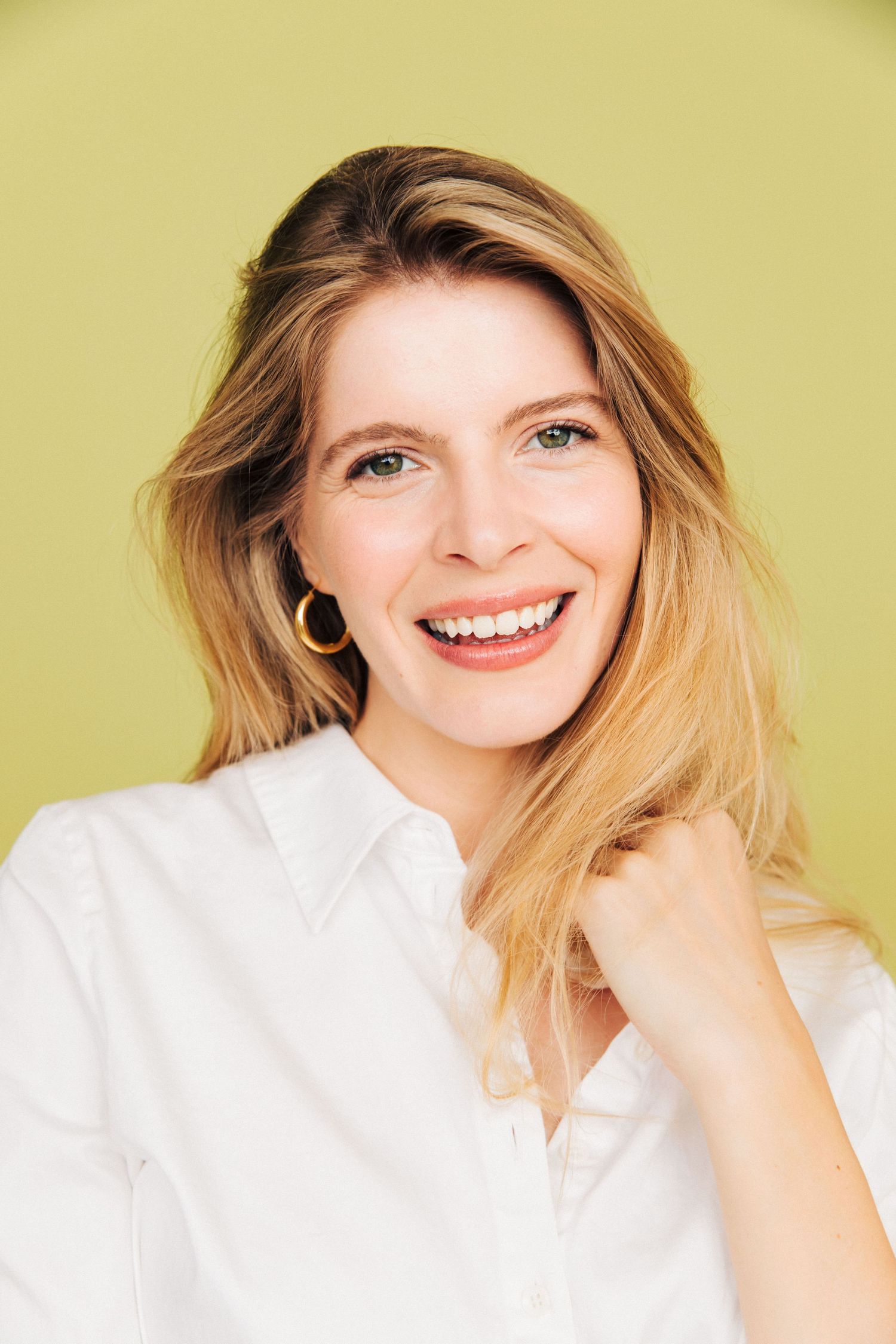 Professional Linkedin headshot of smiling woman with natural green backdrop in Santa Monica studio by LA photographer Phia Photography.