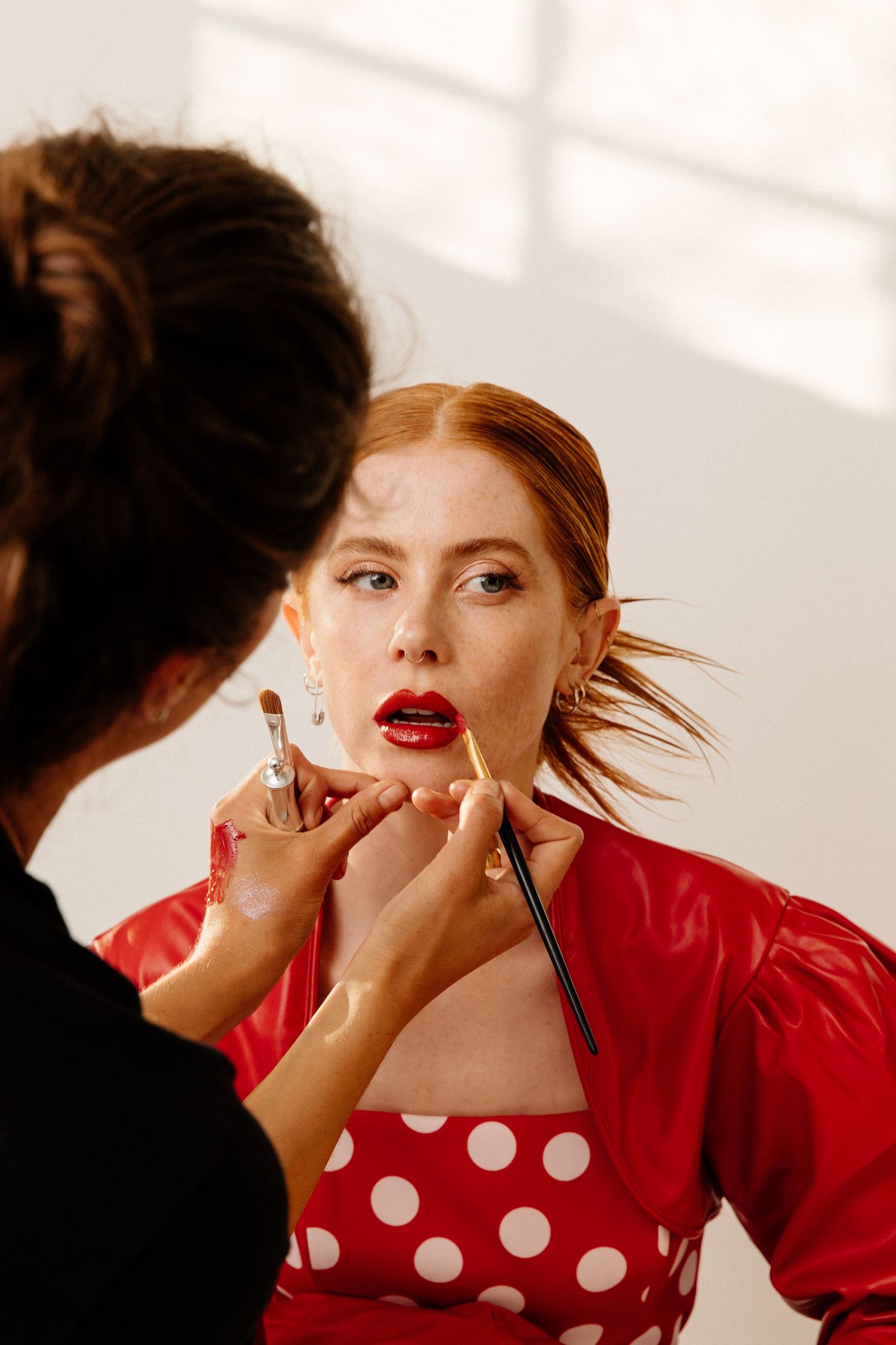 Los Angeles model wearing red receiving makeup services by creative Los Angeles hair and makeup artist in Phia's Santa Monica studio.