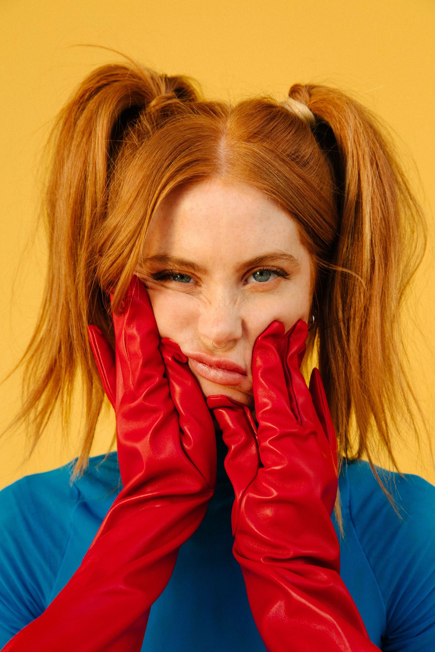 Creative editorial model headshot of redhead woman with red gloves and yellow backdrop in Santa Monica studio by Phia Photography.