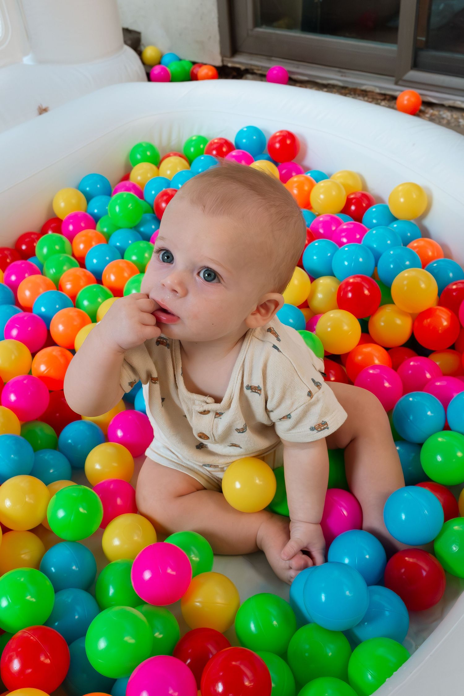 Natural light baby portrait of cute infant playing in colorful ball pit by Los Angeles family photographer Phia Photography.