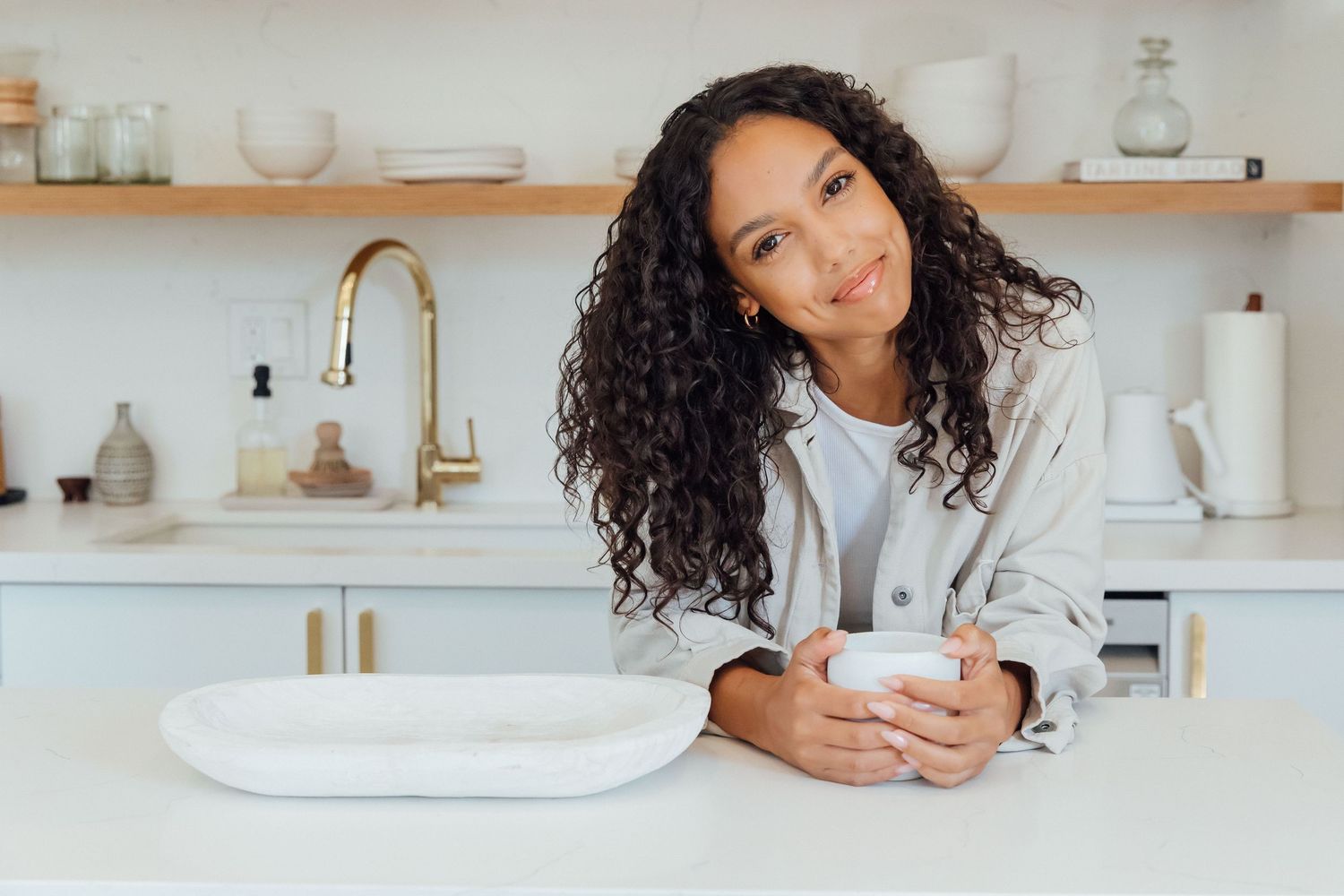 Natural light personal branding portrait of a black woman in a kitchen with coffee in editorial style by photographer Phia Photography.