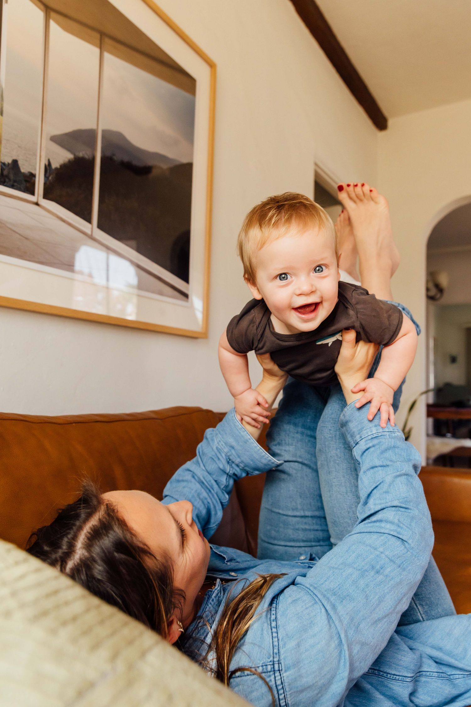 Mom lifting baby in the air laughing at home, lifestyle editorial family photography Los Angeles by photographer Phia Photography