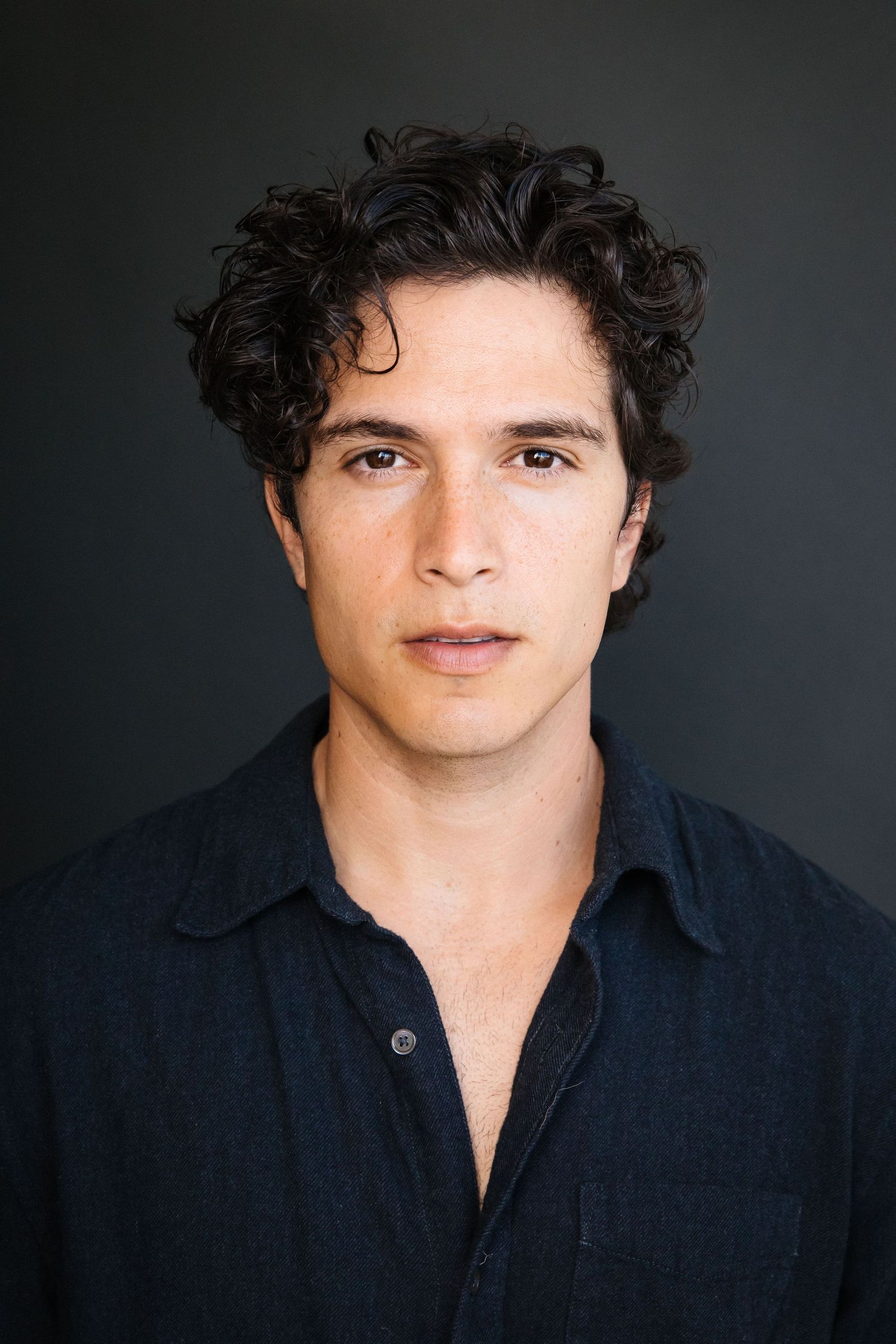 Cinematic actor headshot of a man with dark hair against a dark background in a Santa Monica studio by LA photographer Phia Photography.