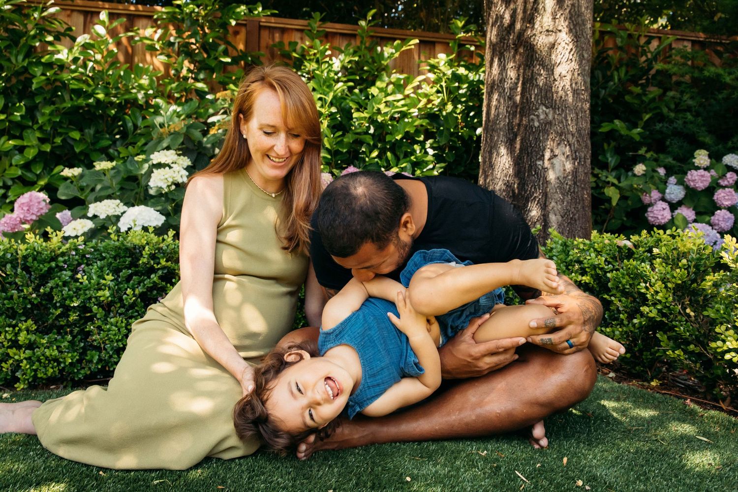 Natural light editorial family portrait of pregnant mother, father and child playing outdoor by Los Angeles photographer Phia Photography.