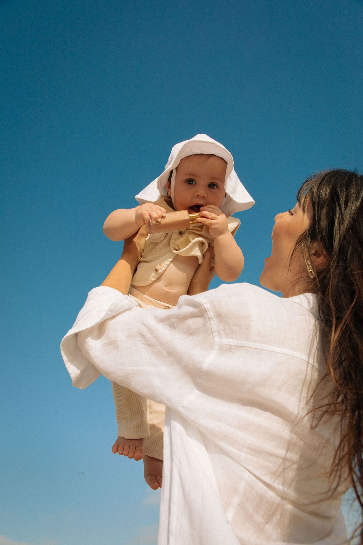 Lifestyle natural light creative portrait of mother holding baby at Santa Monica beach by Los Angeles family photographer Phia Photography.