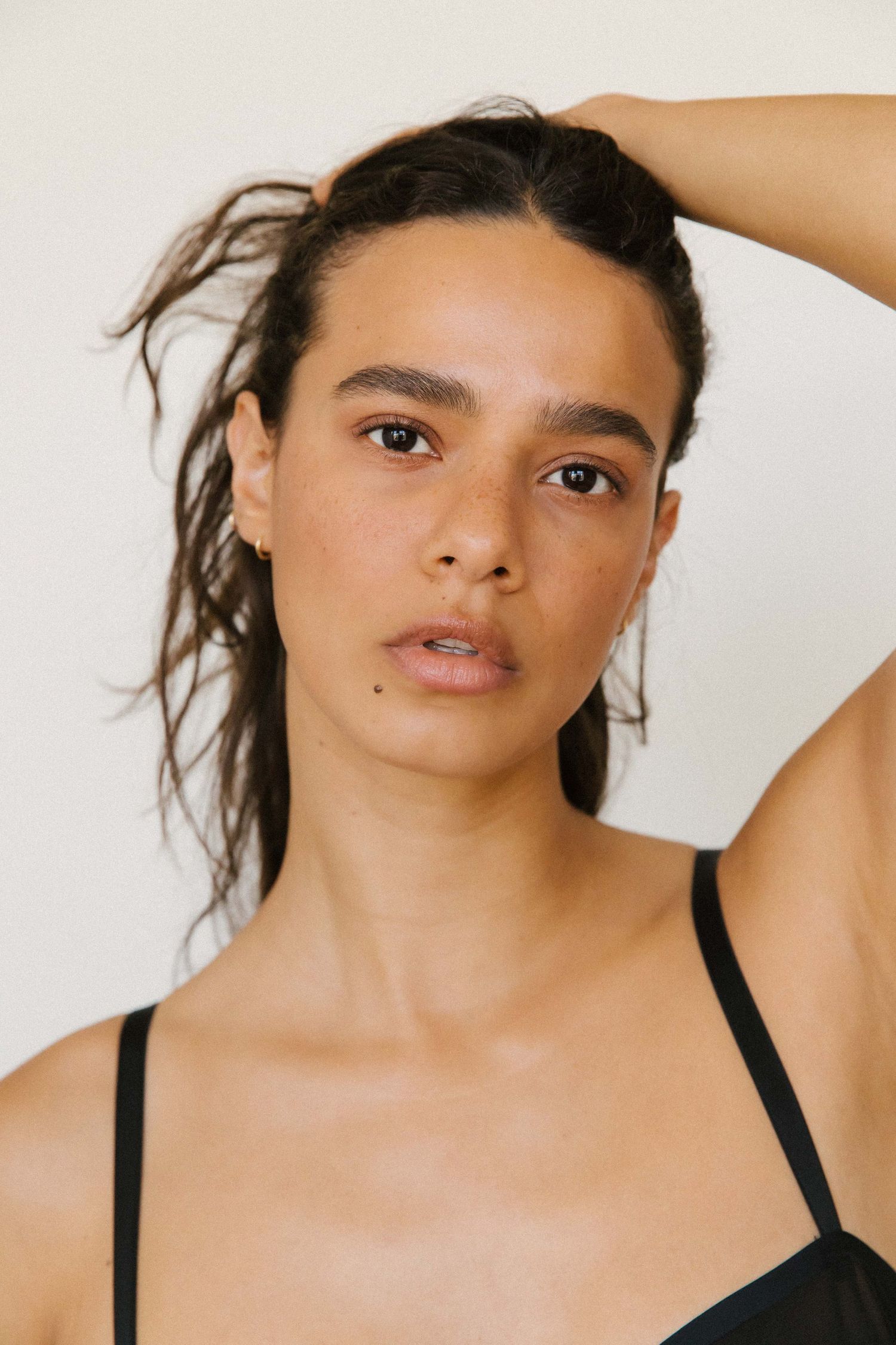 Professional model natural light headshot of woman posed holding hair in Santa Monica studio by Los Angeles photography Phia Photography.