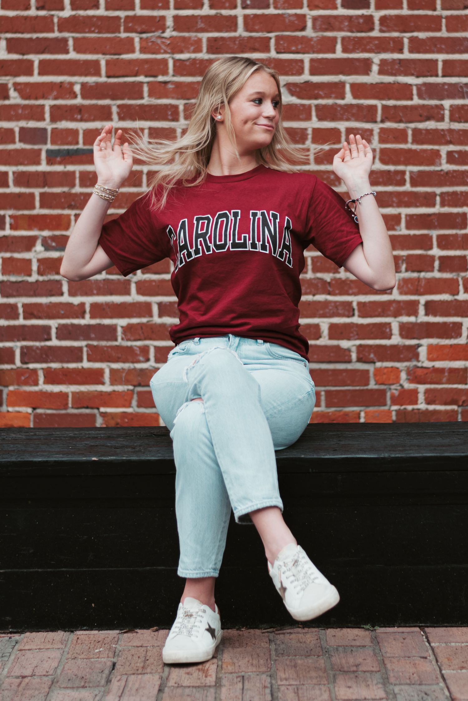 High school senior girl in University of South Carolina Gamecocks t-shirt, tossing hair, in downtown Walterboro, South Carolina