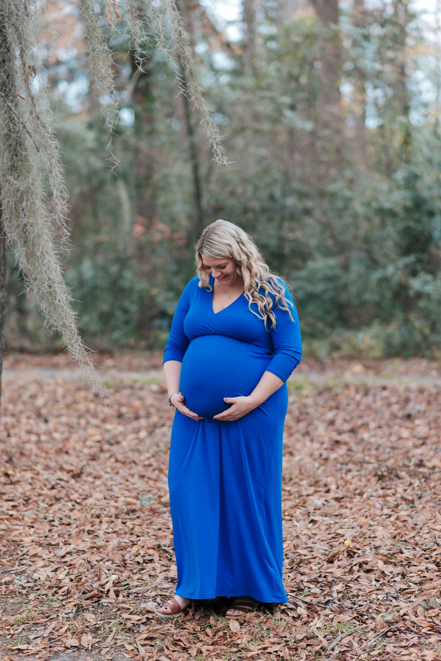 Mom holding baby bump in front of trees at Lake Warren in Hampton, SC.
