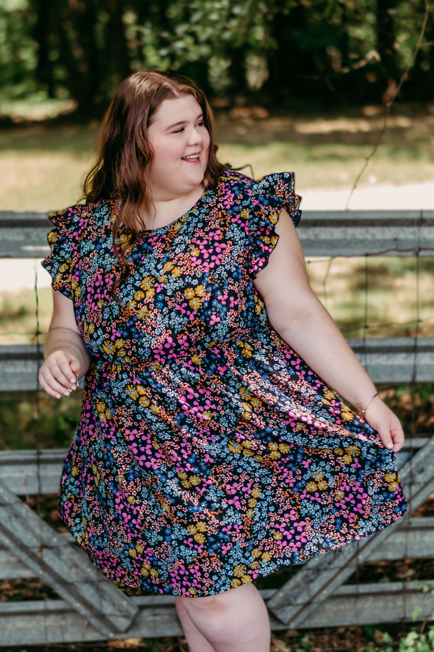 High school senior girl in vibrant floral dress at farm in Cartersville, Georgia