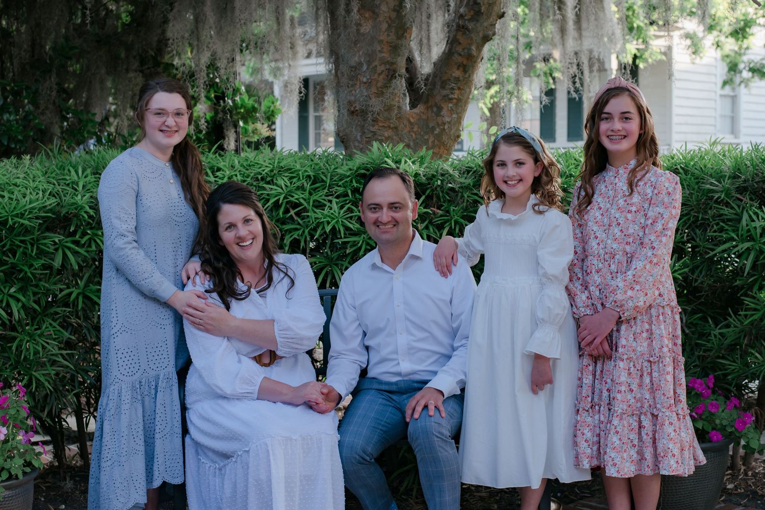 Mom and dad surrounded by three daughters dressed in shades of blue, pink and white. Downtown Beaufort, South Carolina