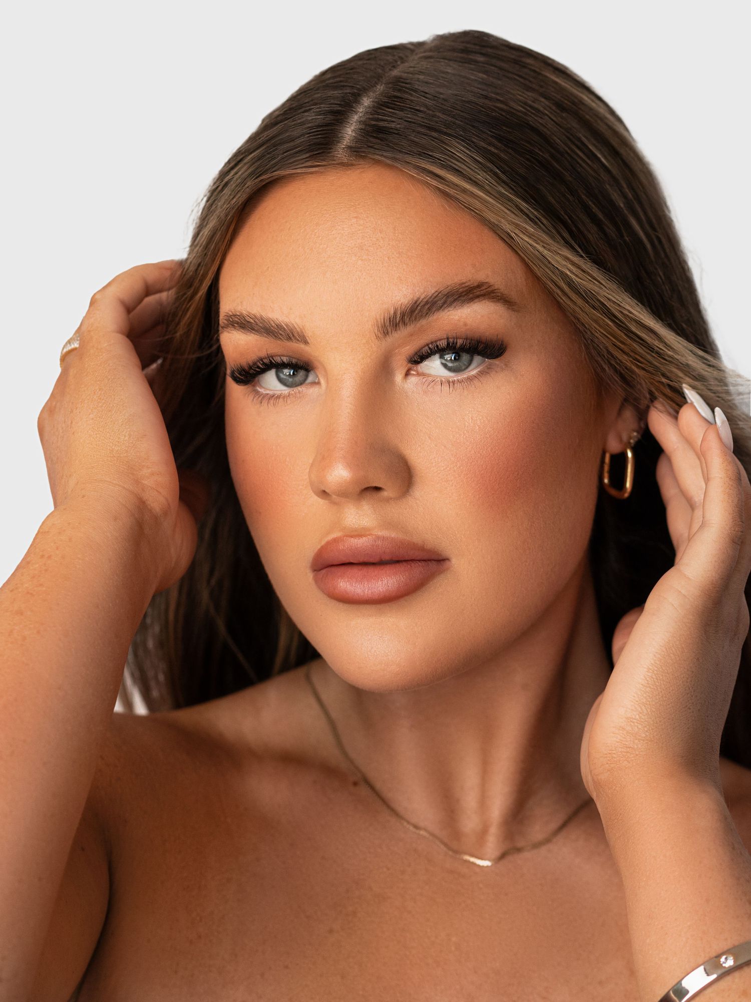Dramatic beauty portrait showcasing defined makeup and expertly styled hair.
