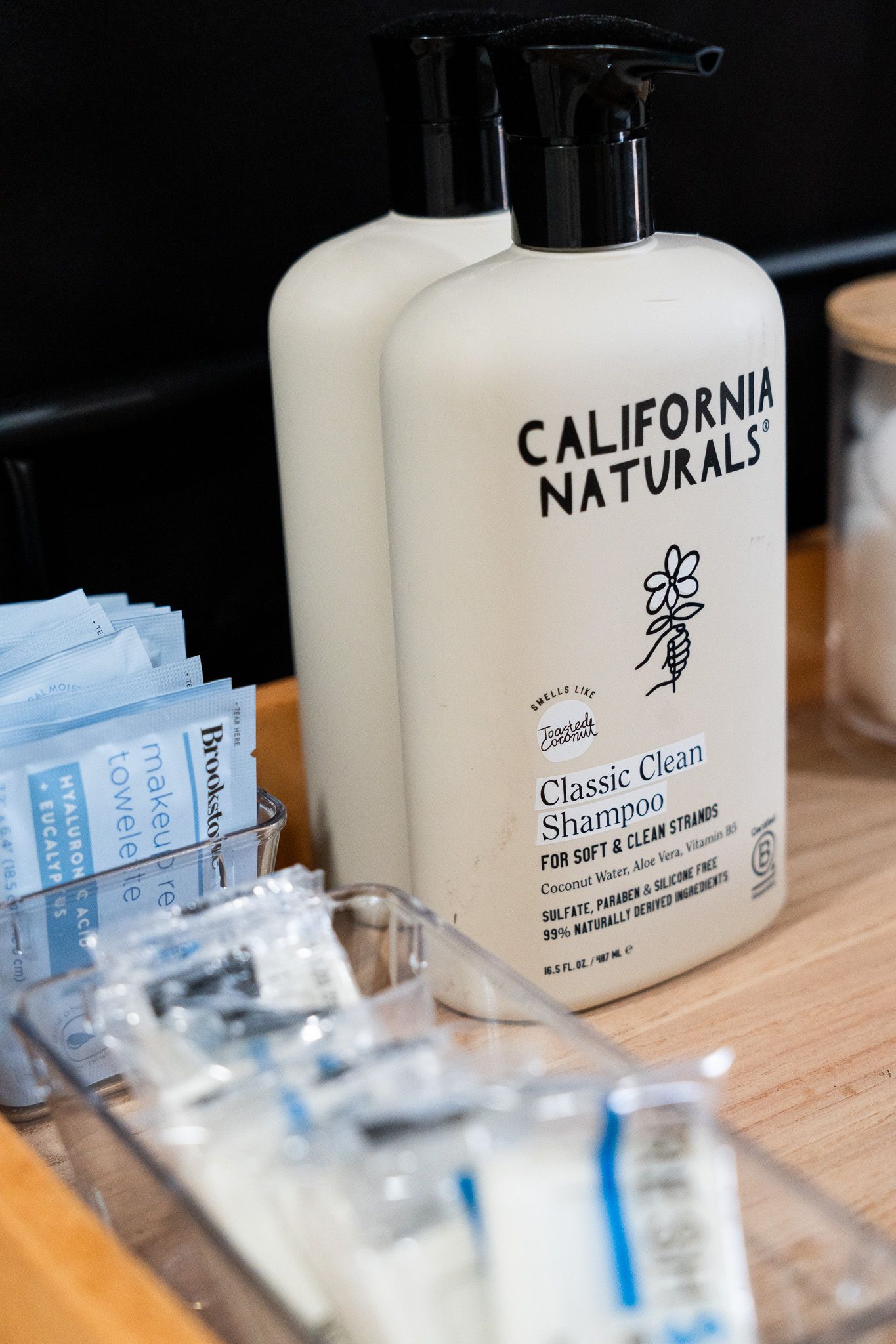 California Naturals toiletry products and amenities displayed on wooden surface.
