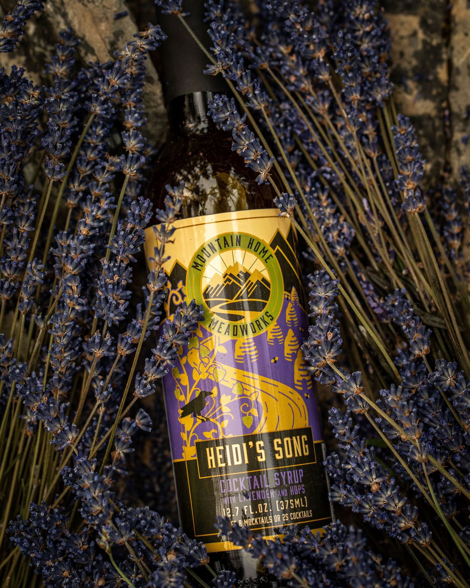 Bottle of Heidi's Song liqueur artfully placed among blooming lavender stalks.
