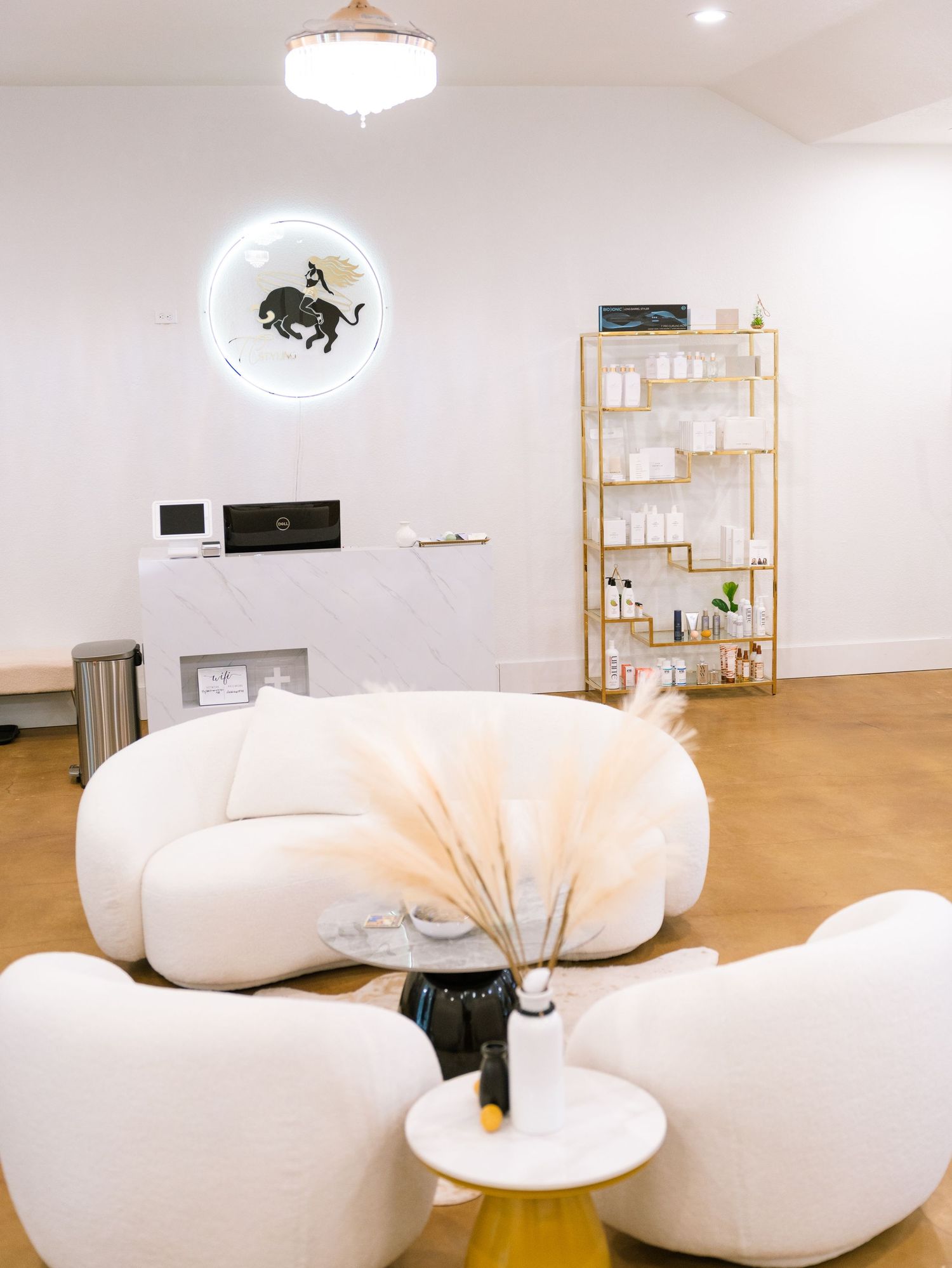 Modern lounge area with plush white chairs and circular wall art in minimalist design.