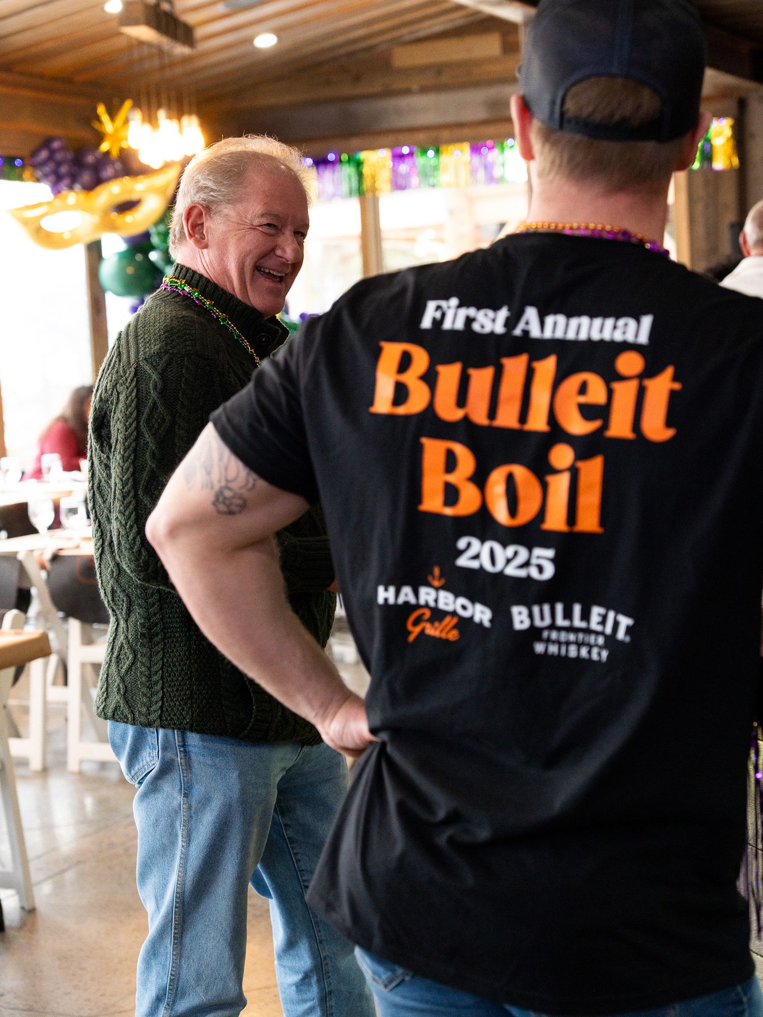 Event staff member wearing First Annual Bulleit Boil 2023 t-shirt at indoor venue.