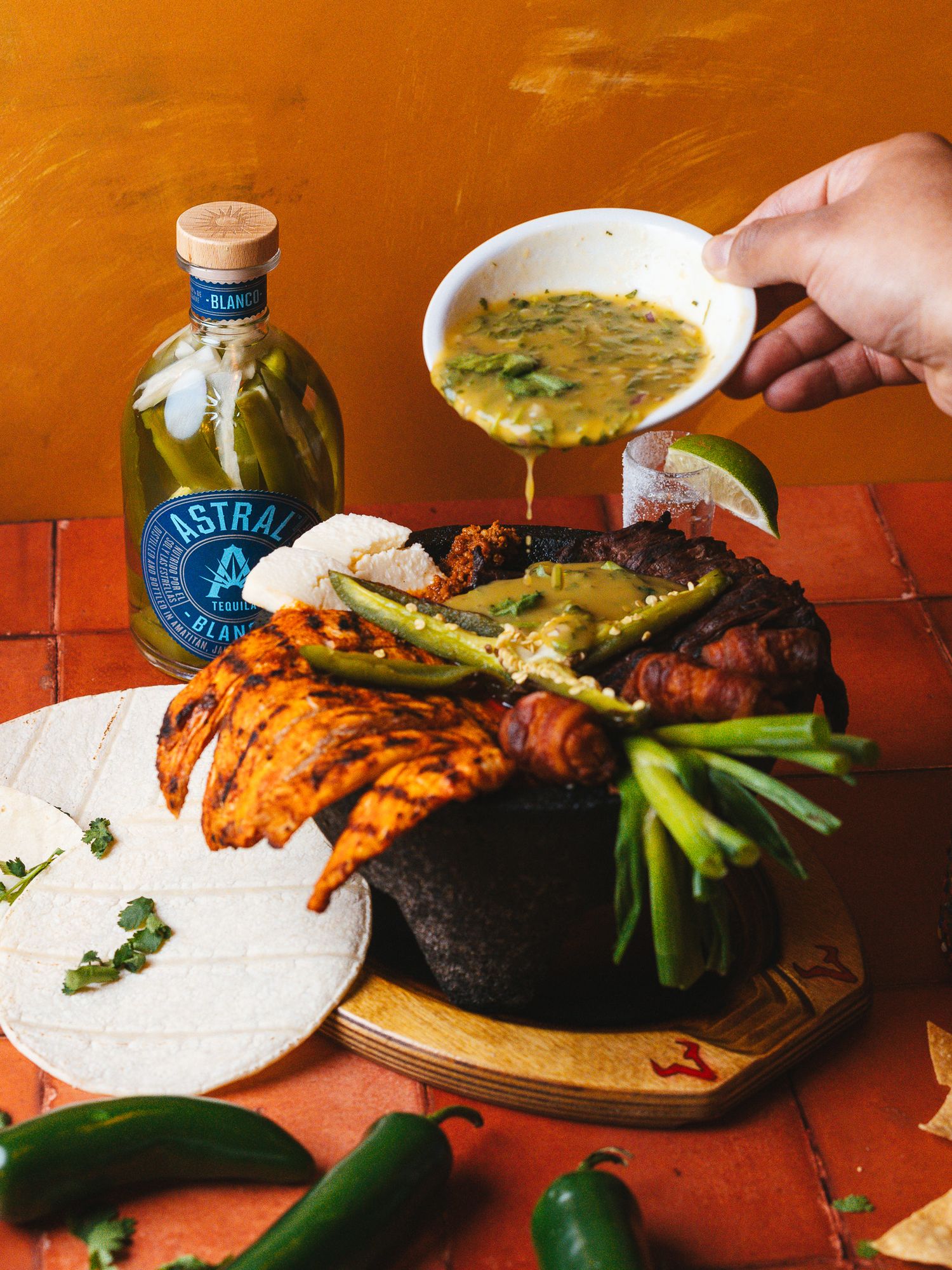 Mexican-style fajita platter with grilled meats, peppers and tortillas being served.