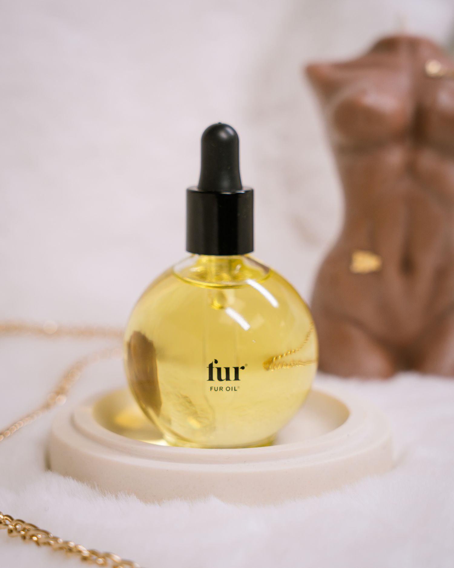 Yellow perfume oil bottles with dropper caps displayed on cream surface.