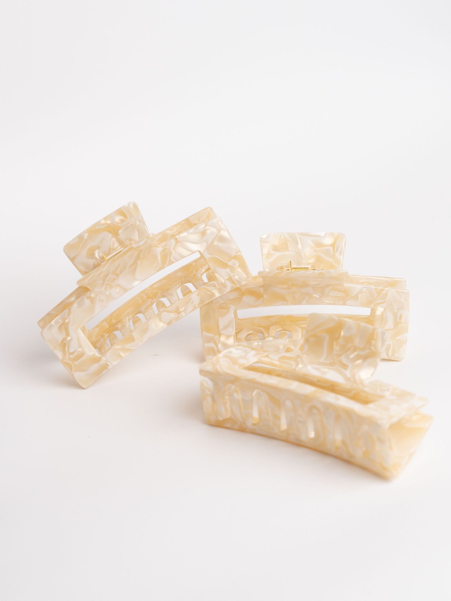 Close-up sequence of off-white textured paper or material strips against white background.