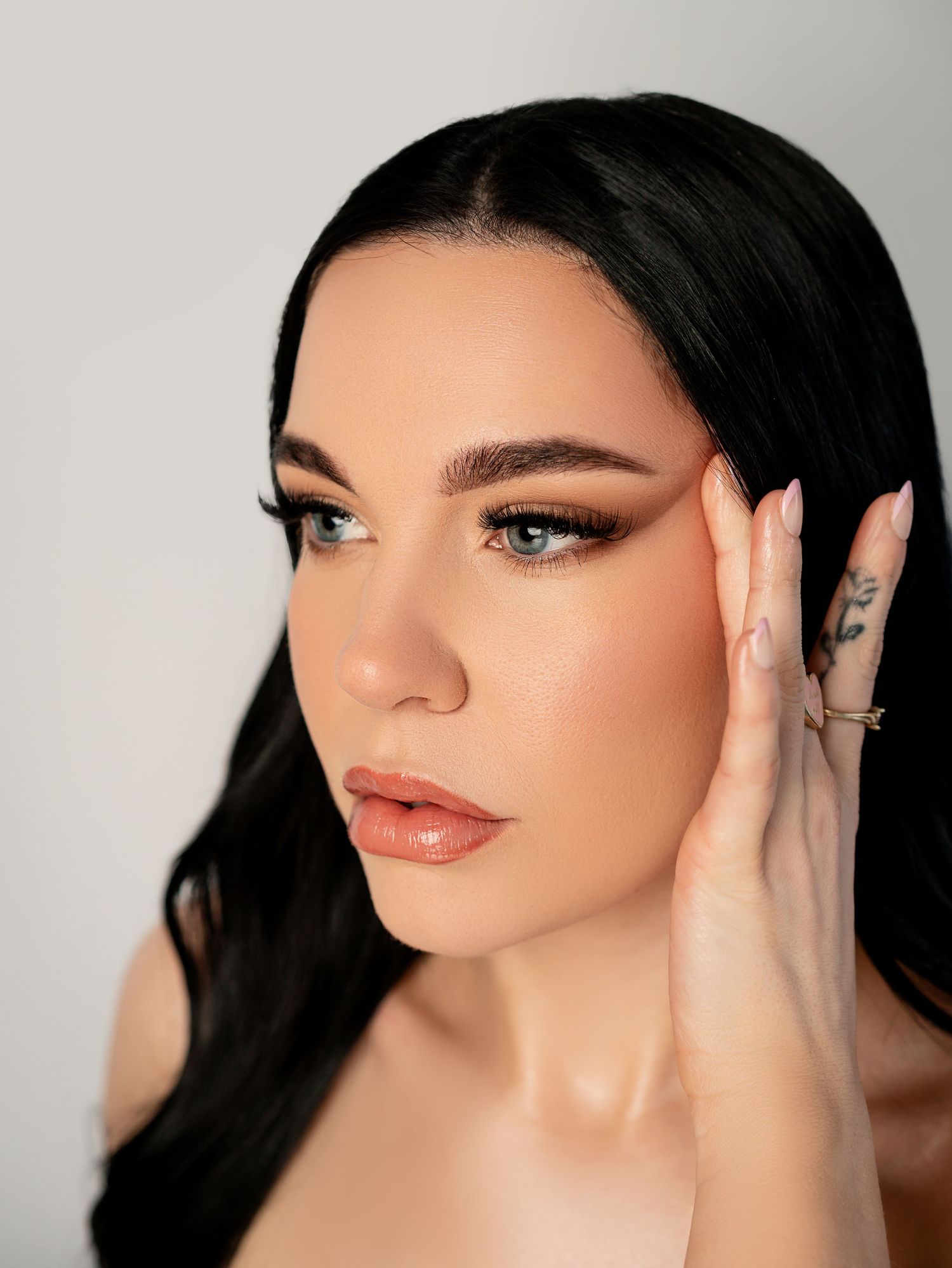 Close-up beauty portrait showcasing dramatic eye makeup and flawless complexion.