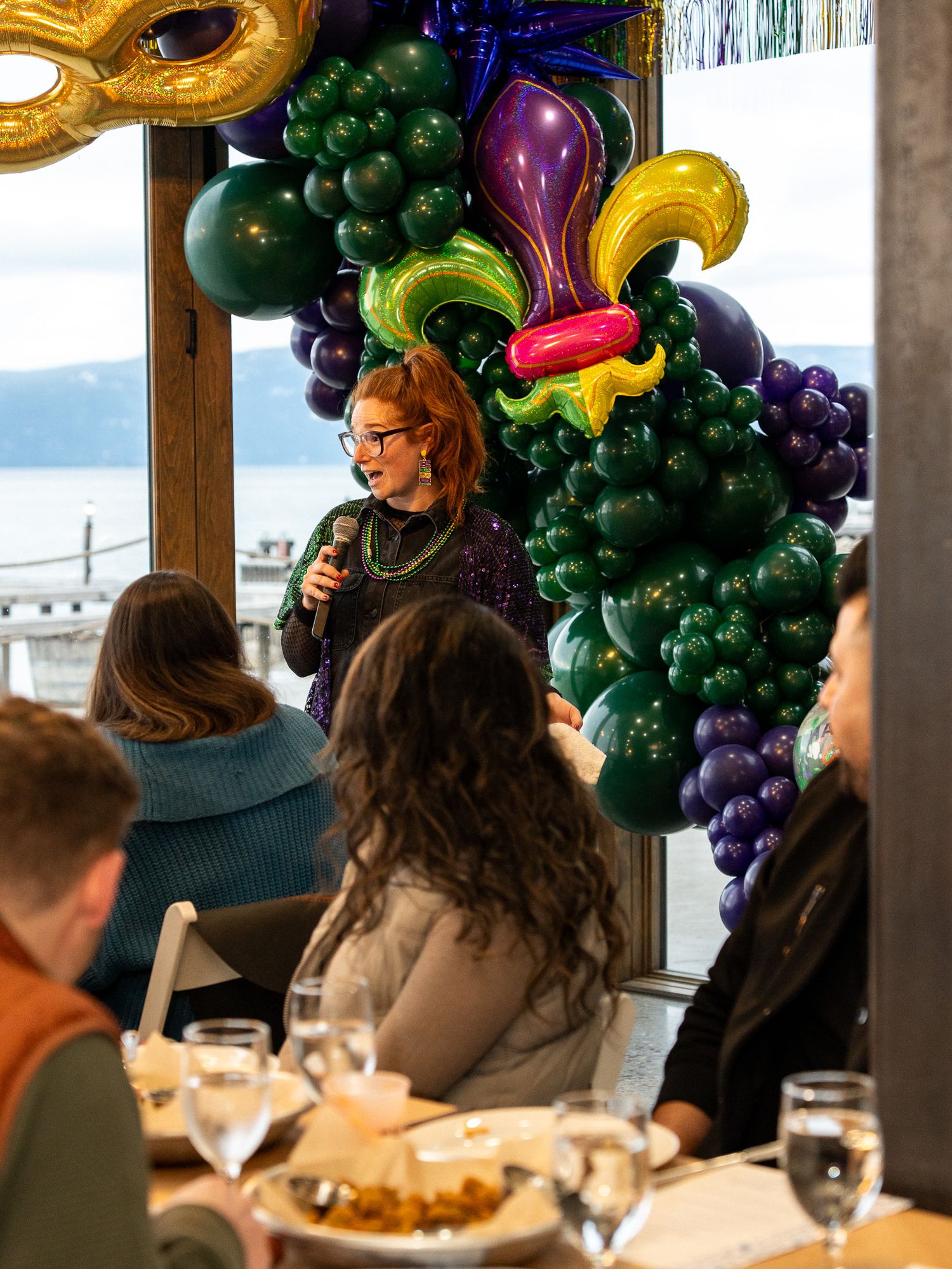 Festive party scene with elaborate balloon decorations featuring grape clusters and colorful designs.