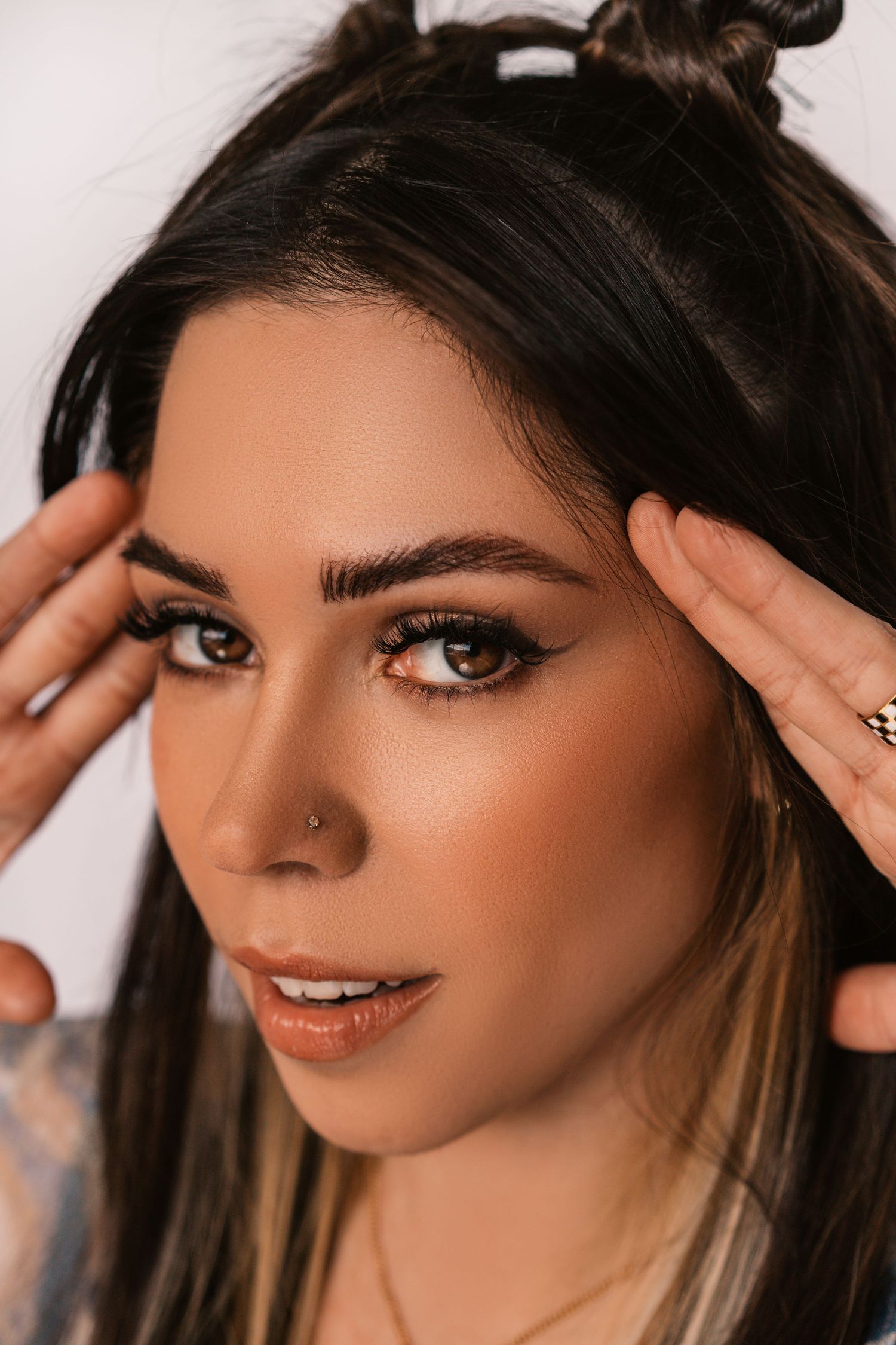 Glamour beauty portrait series featuring dramatic eye makeup and styled dark hair.