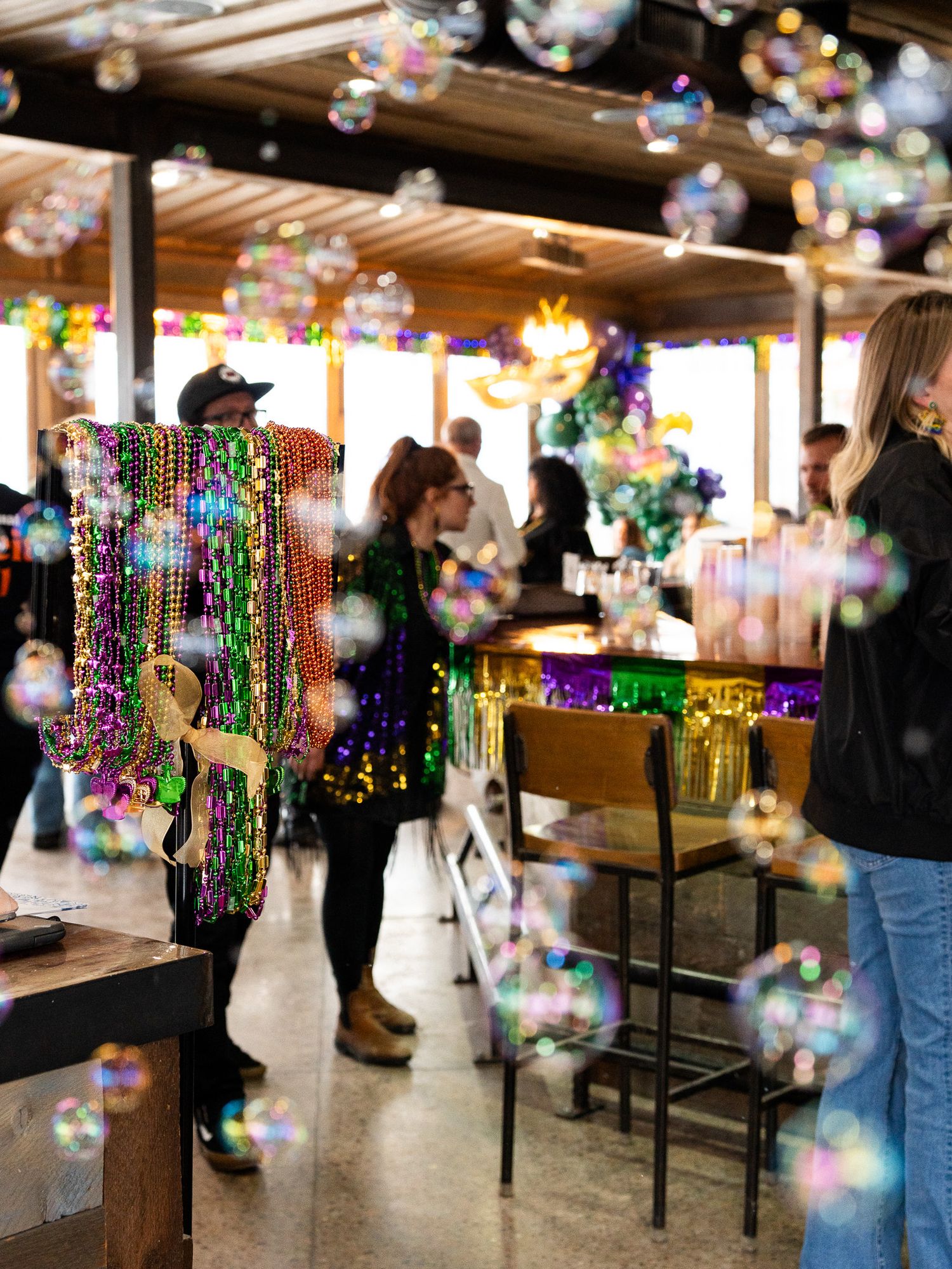 Festive bar scene with hanging beads and bubble bokeh effects creating a celebratory atmosphere.