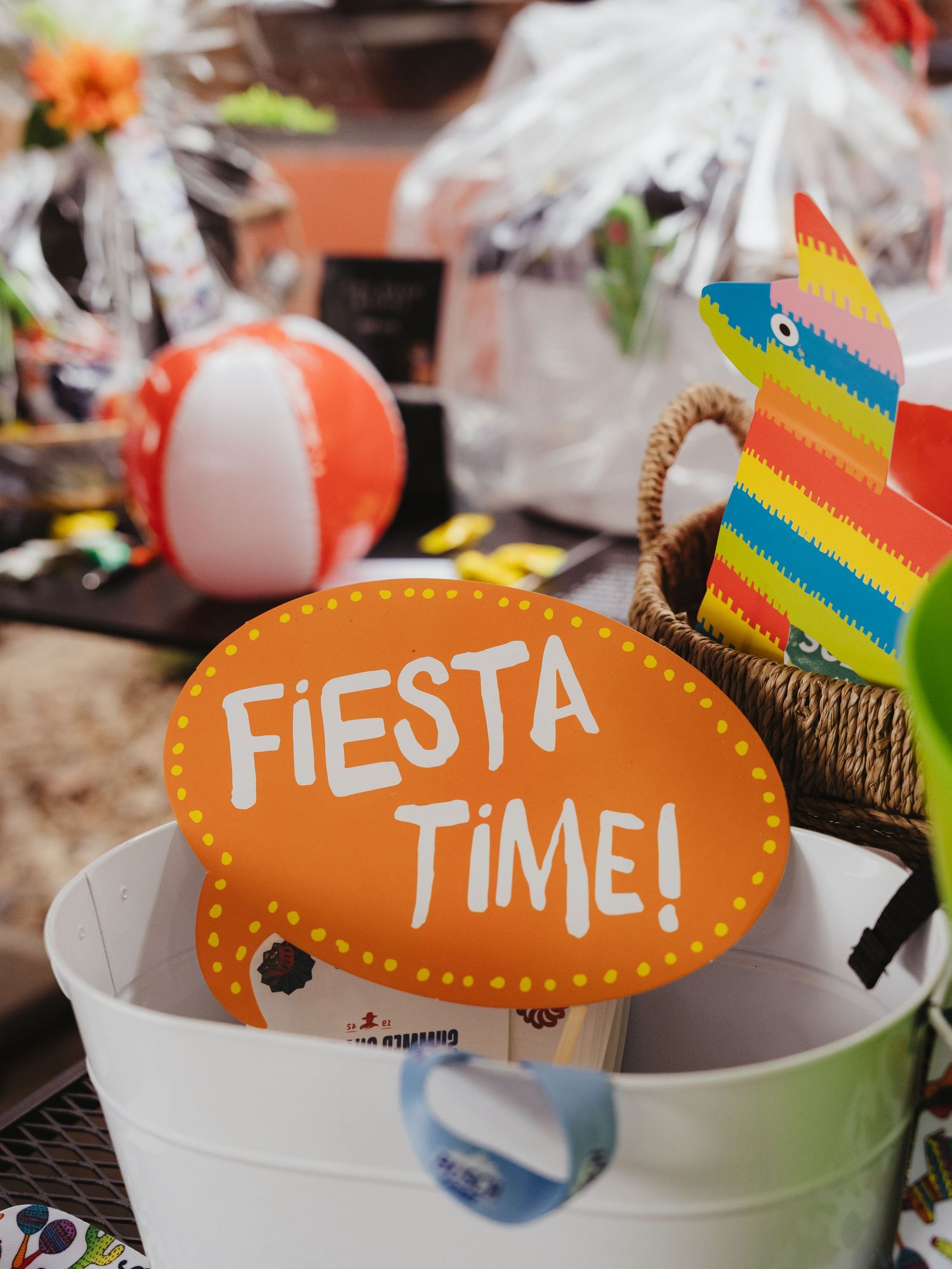 Colorful fiesta decoration with orange sign and rainbow striped party accessories.