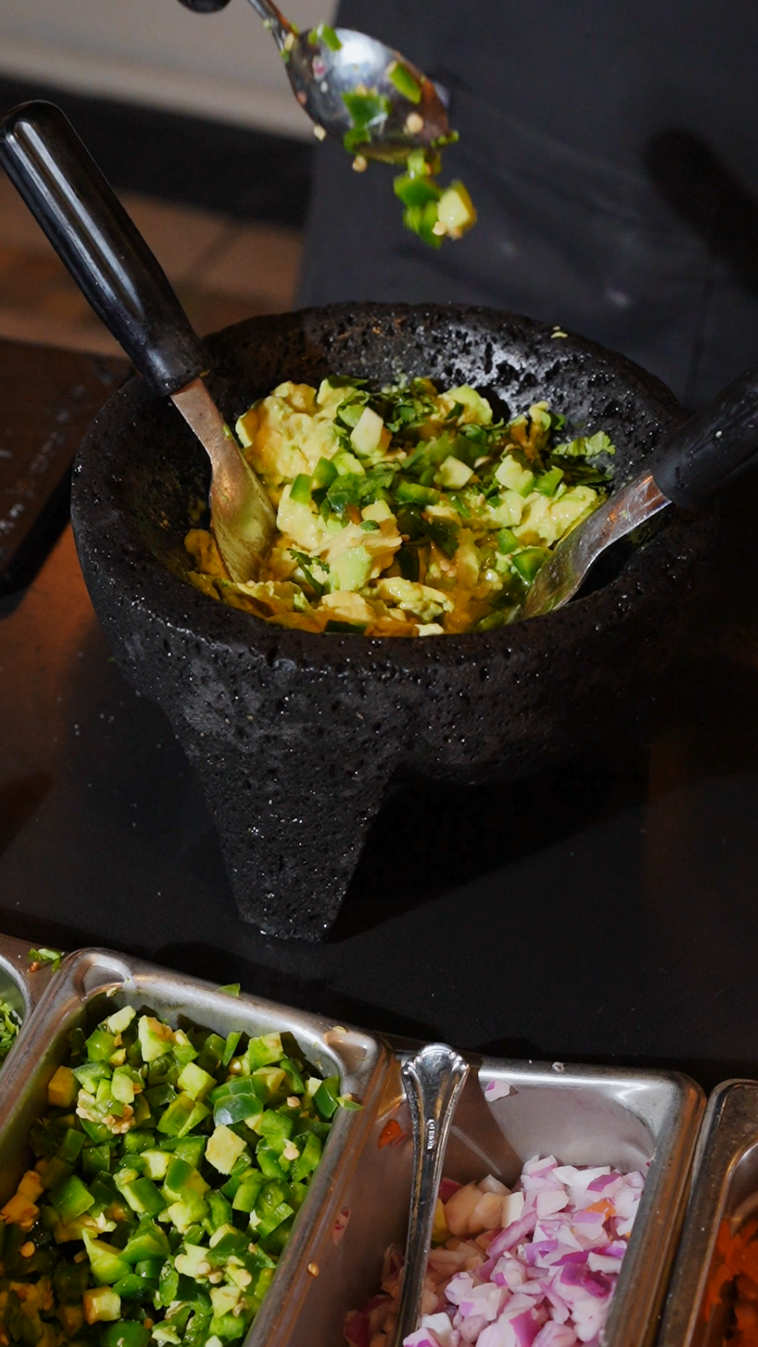 A stir fry dish being prepared in a wok with fresh vegetables and colorful ingredients.