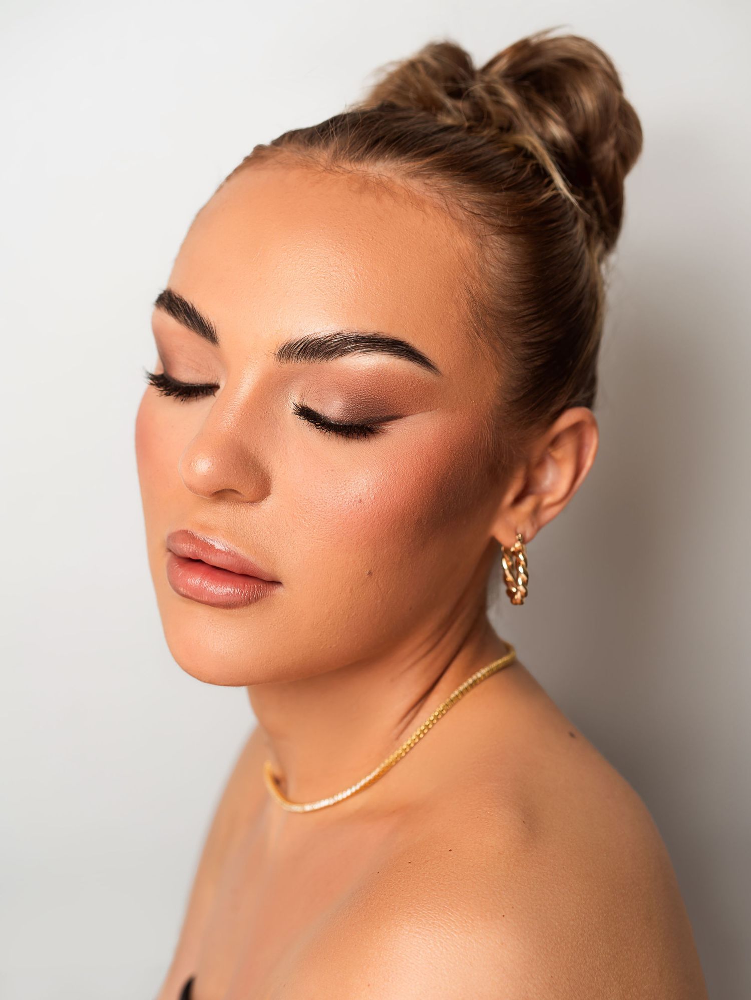 Studio beauty portrait showing glamorous makeup with matte lipstick and defined brows.