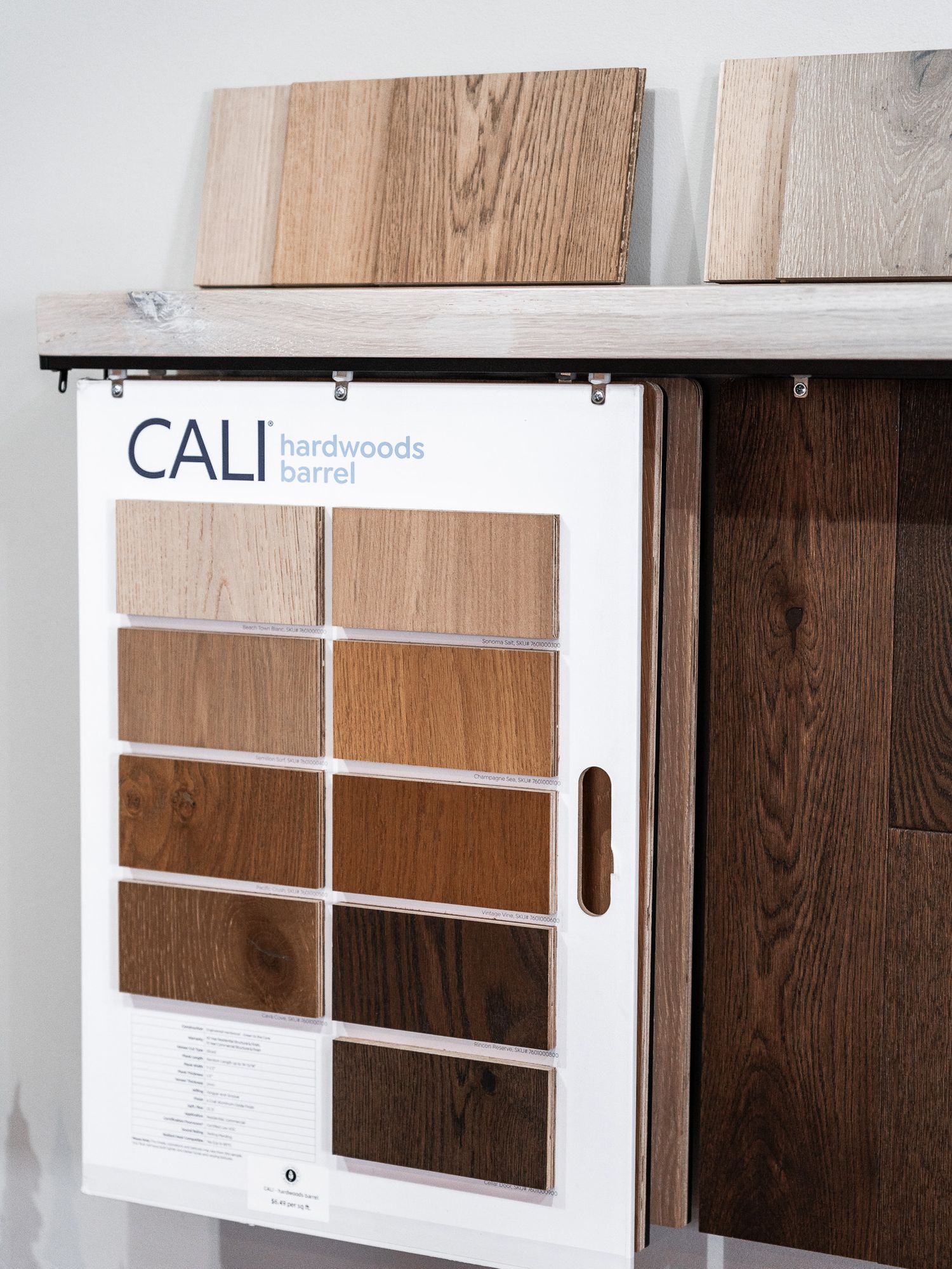 Wood floor and wall samples displayed in clean modern showroom setting.
