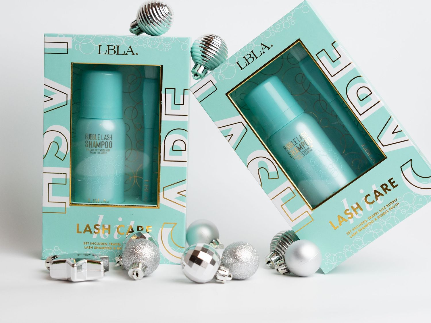 Two turquoise gift boxes with silver ornaments displayed on white background.