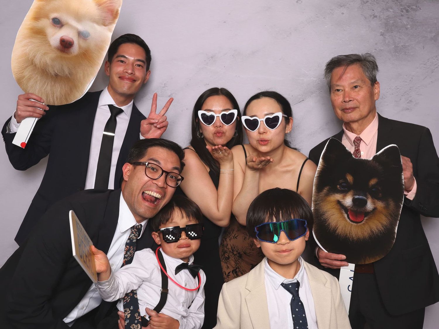 Fun group photo booth picture with family holding oversized dog face props.
