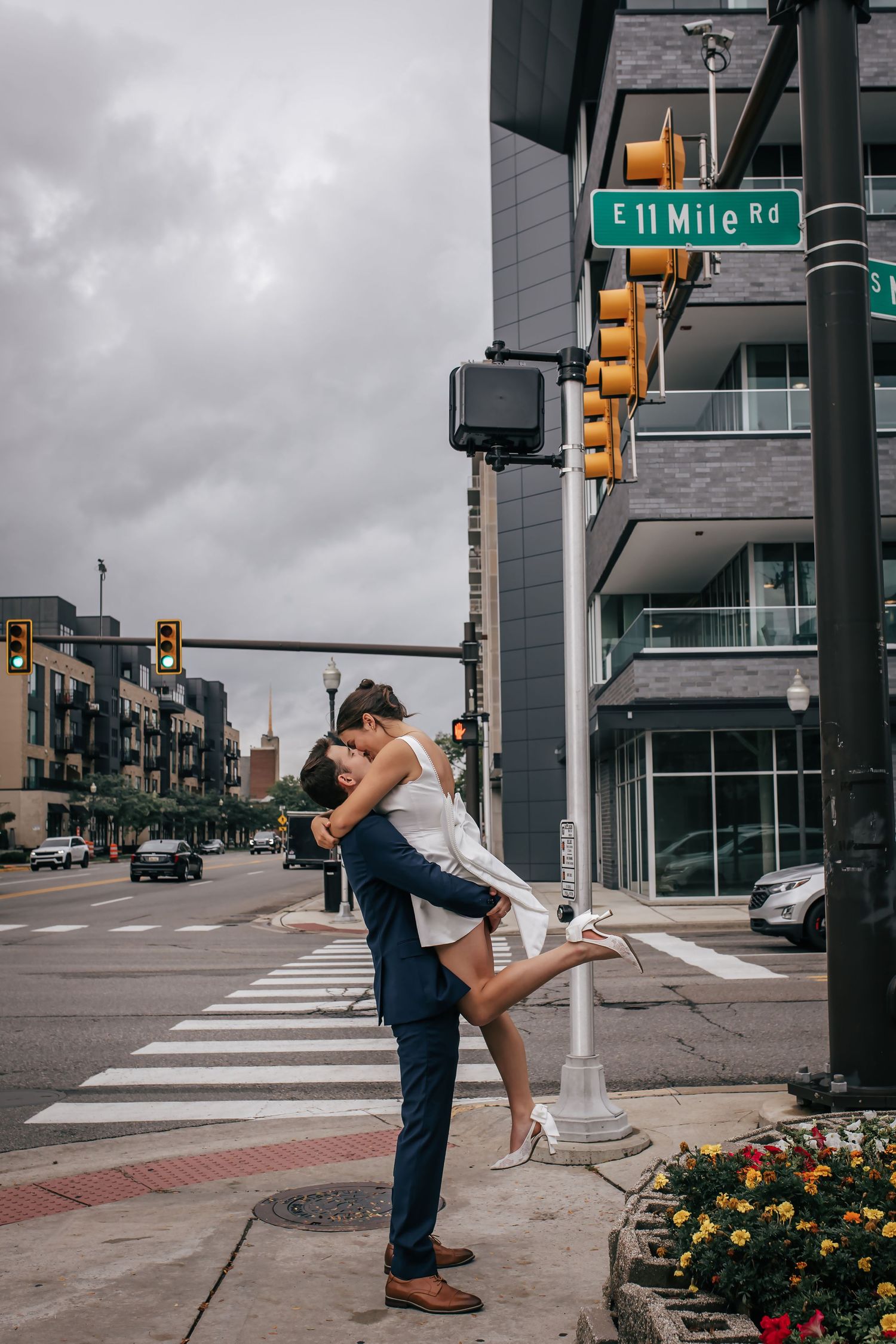 Couple sharing a romantic lift and kiss at E 11 Mile Rd intersection in Royal Oak, Michigan on their wedding day.