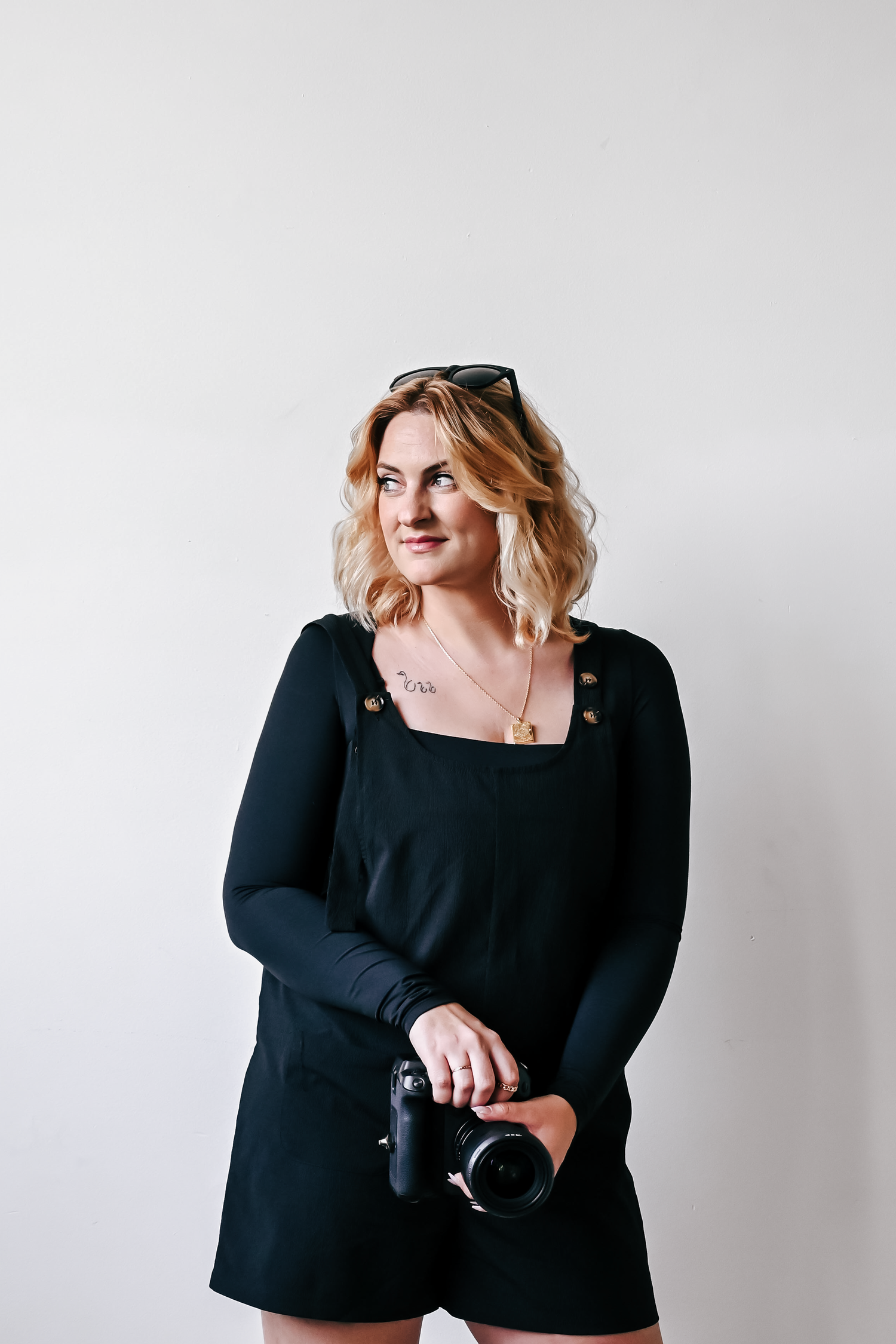 Professional studio portraits in a minimalist white setting with black attire.