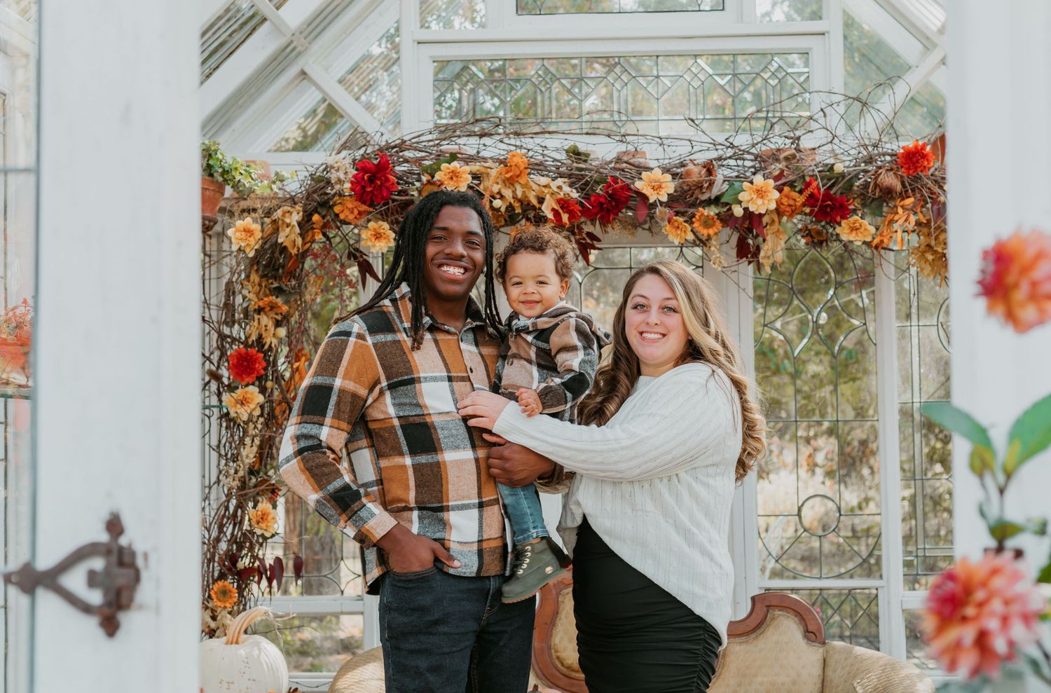 Happy celebration scene in a greenhouse decorated with autumn flowers and natural light.