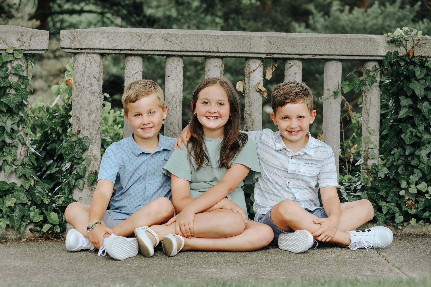 Children sitting together on stone steps for a casual outdoor portrait.