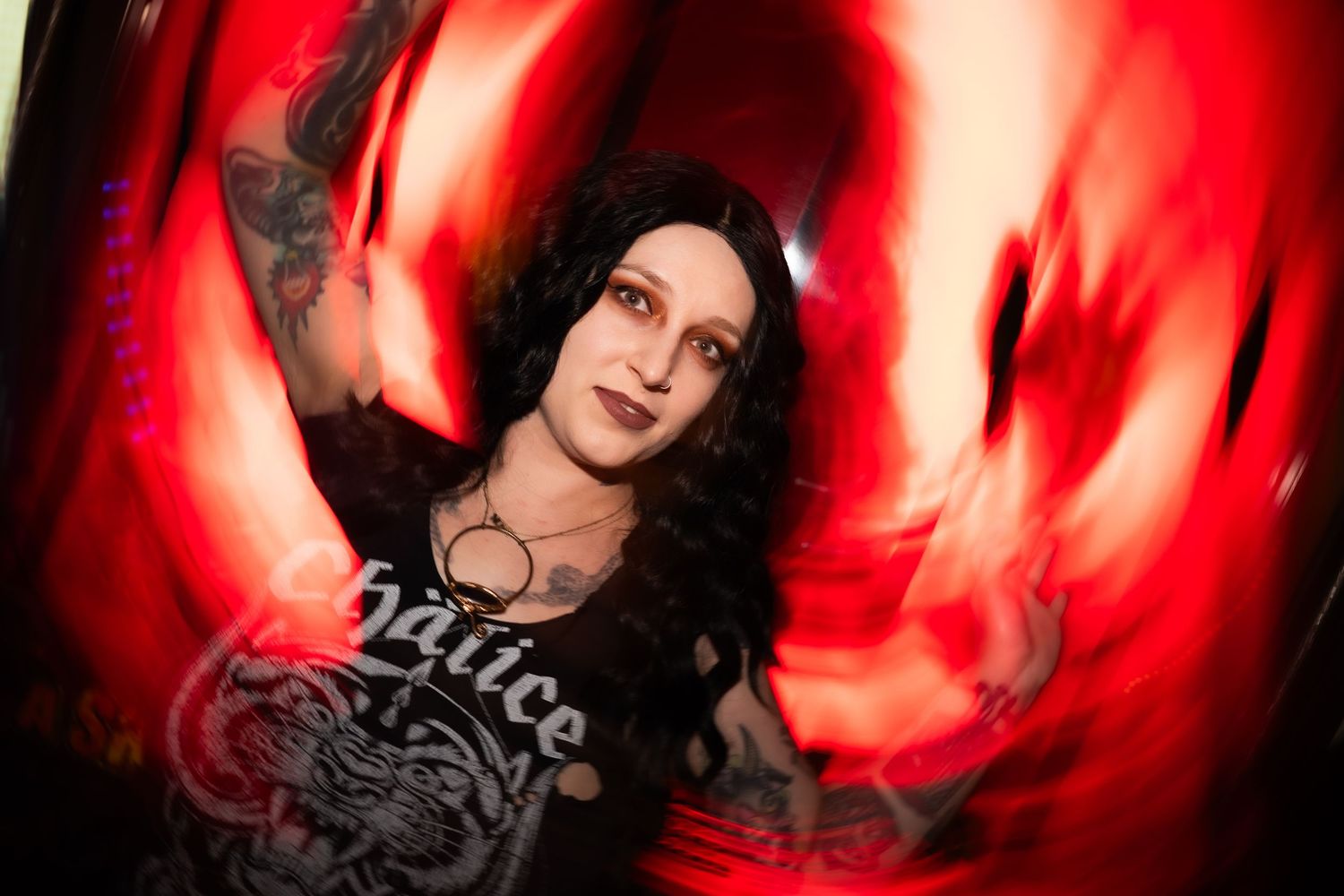 Woman in graphic tee with dramatic red swirling light photography.