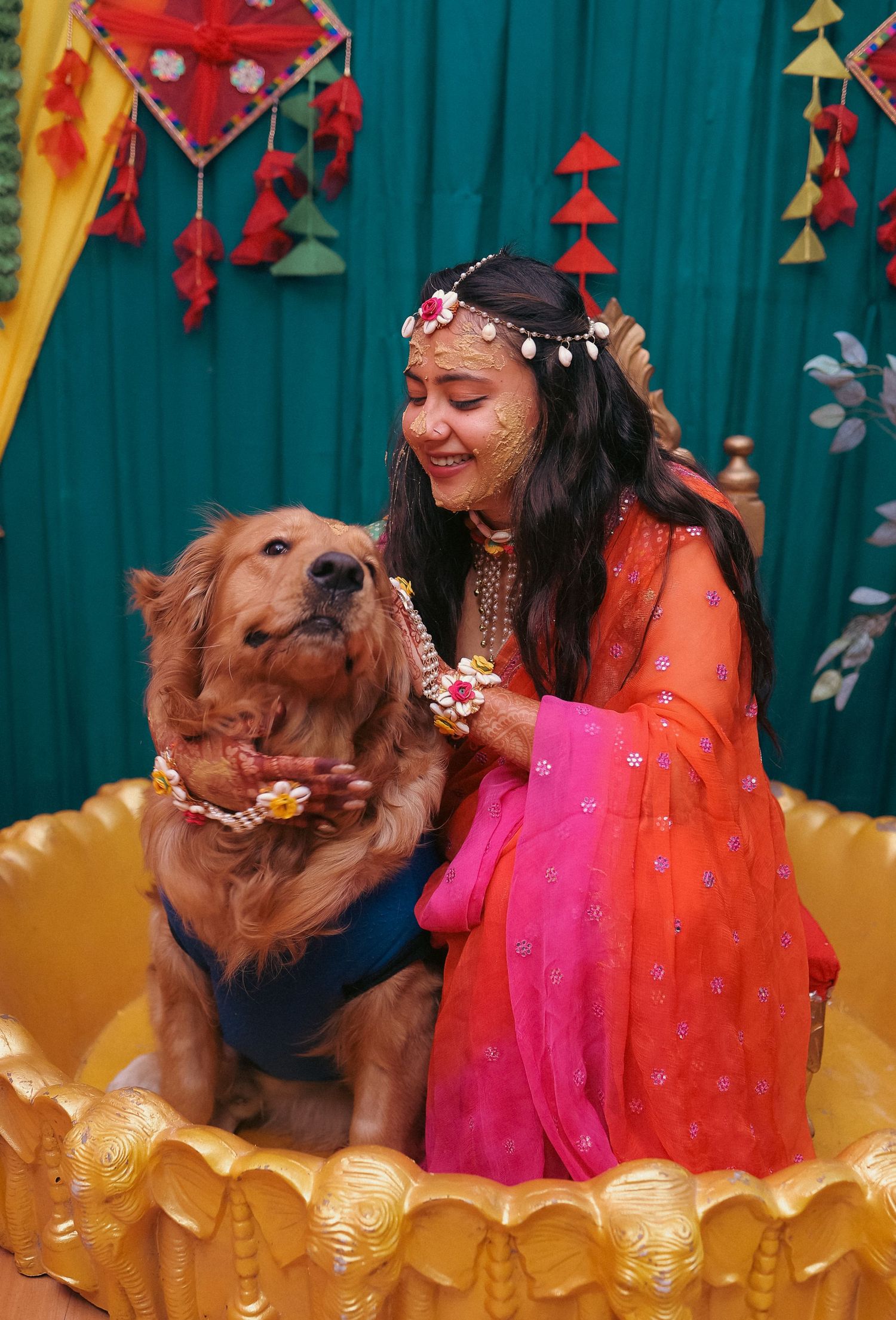 Playful moments between golden retriever and person during colorful festive photoshoot.