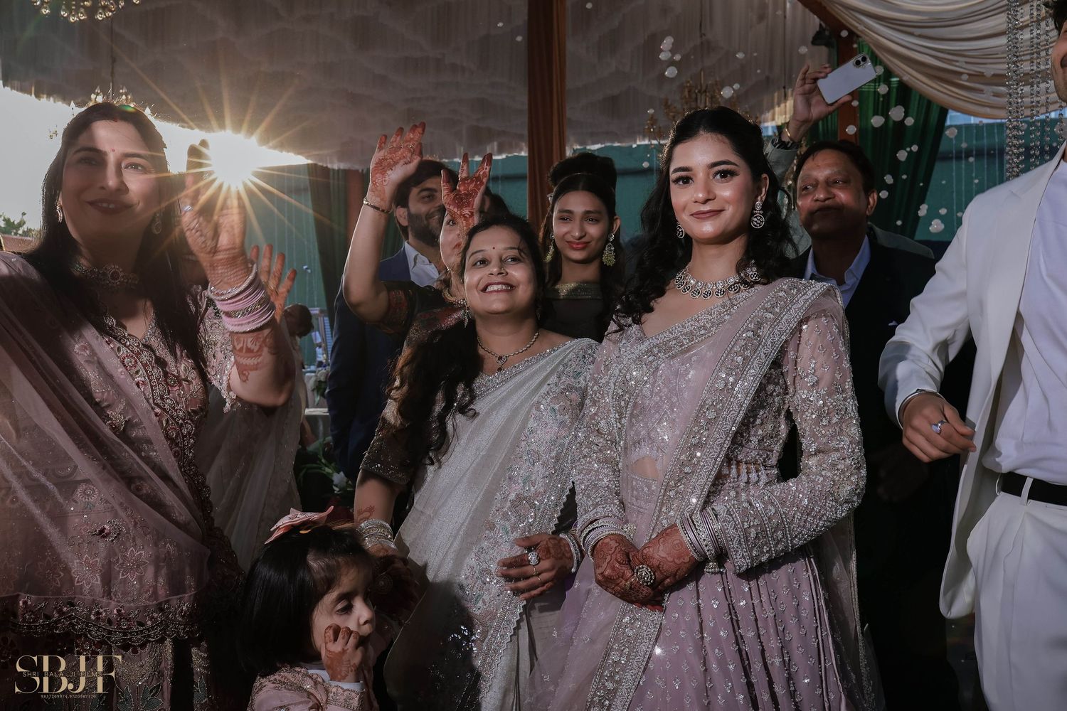 A group celebrates at an elegant wedding reception with sparklers and festive decorations.